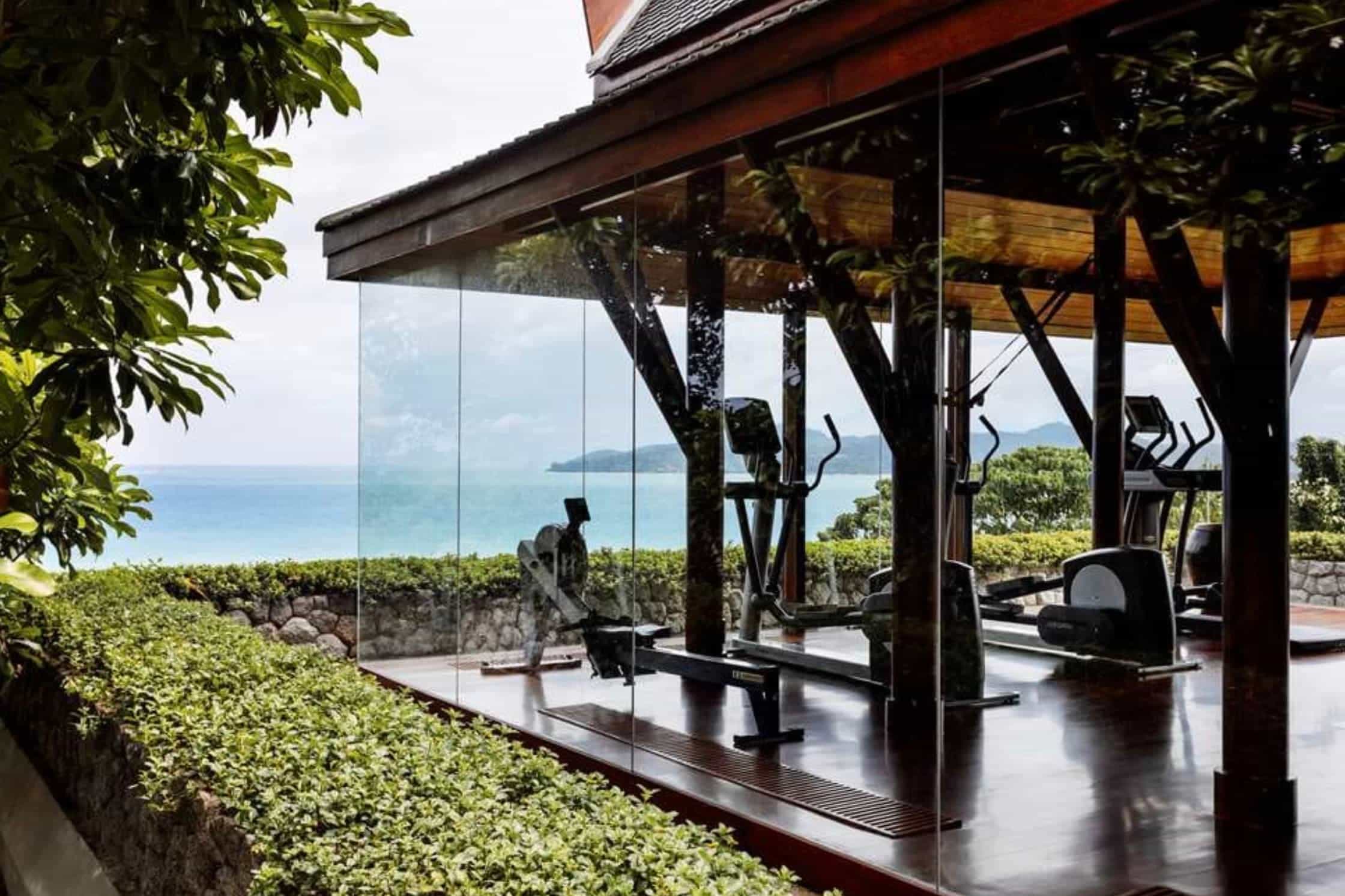 a fancy hotel gym overlooking the ocean
