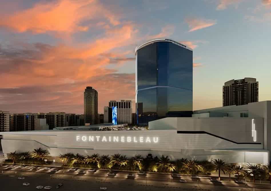 The facade of the Fontainebleau hotel in Las Vegas at sunset with a purple cloudy sky.