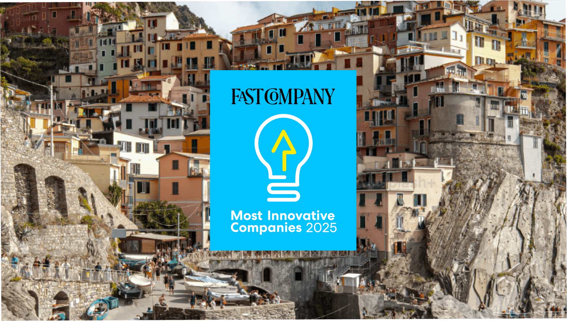 blue fast company logo on a background of a European hilltown