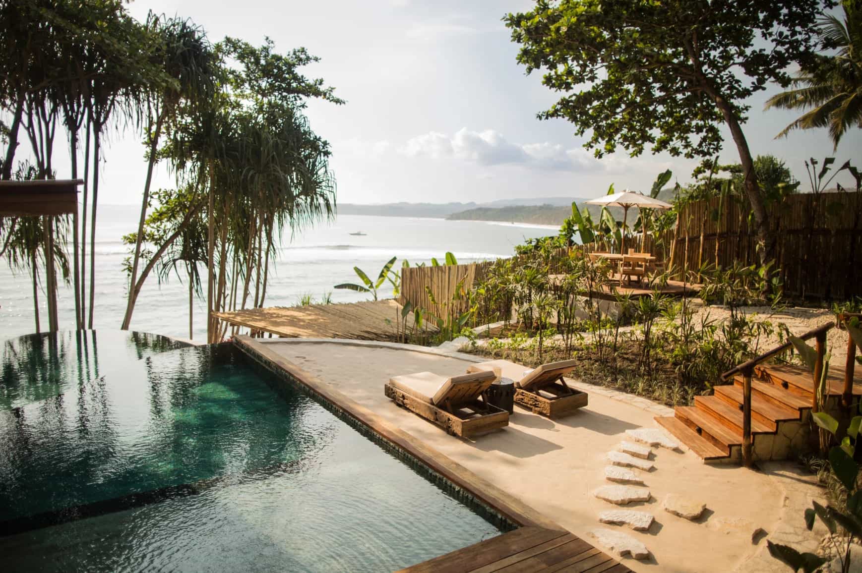 A hotel infinity pool with lush surroundings overlooking the ocean