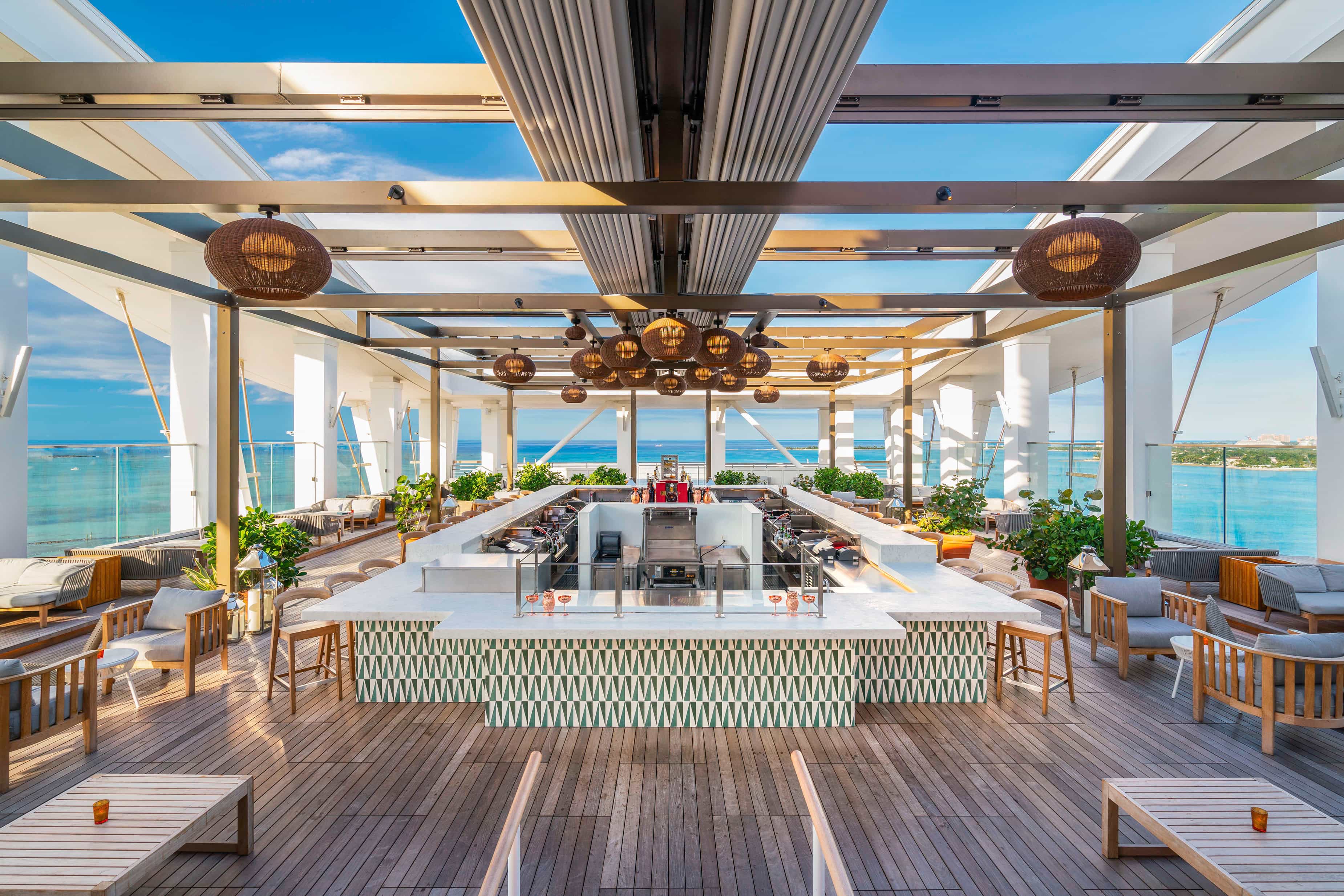 A modern open-air bar and terrace area with ocean views