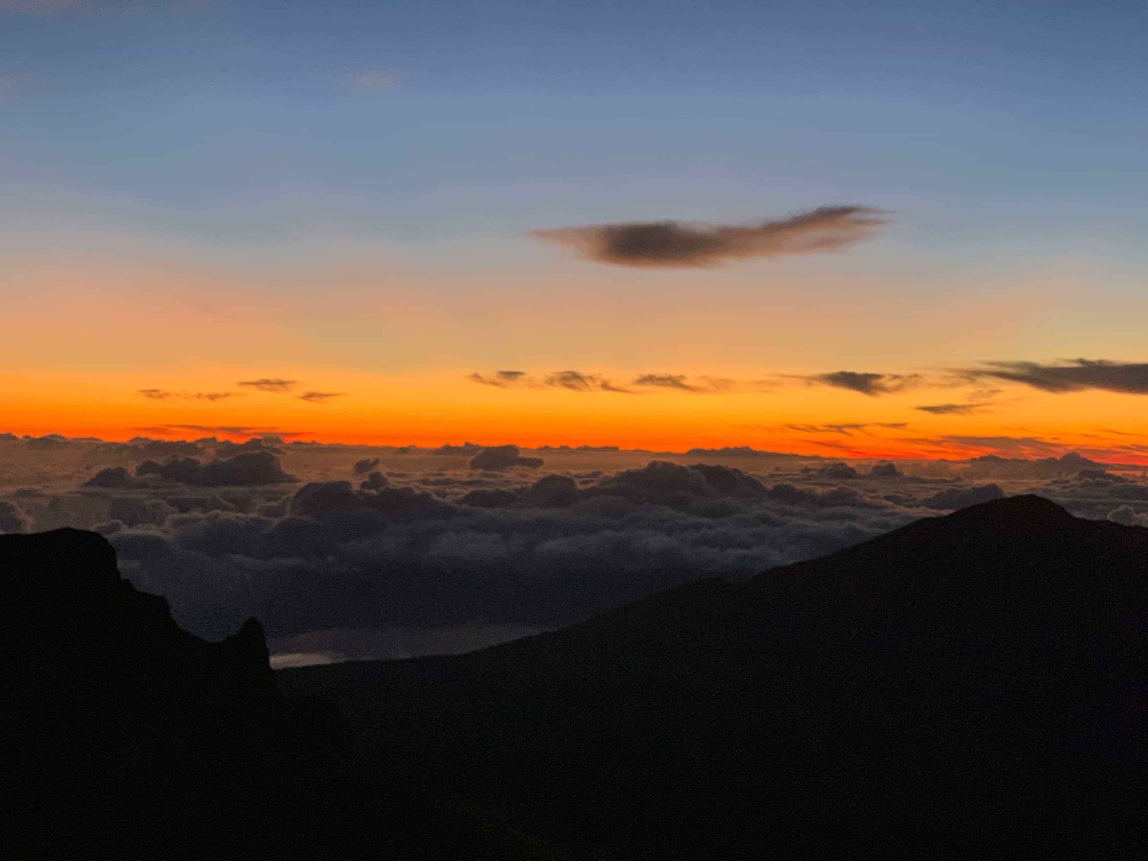view of the sun rising above the clouds