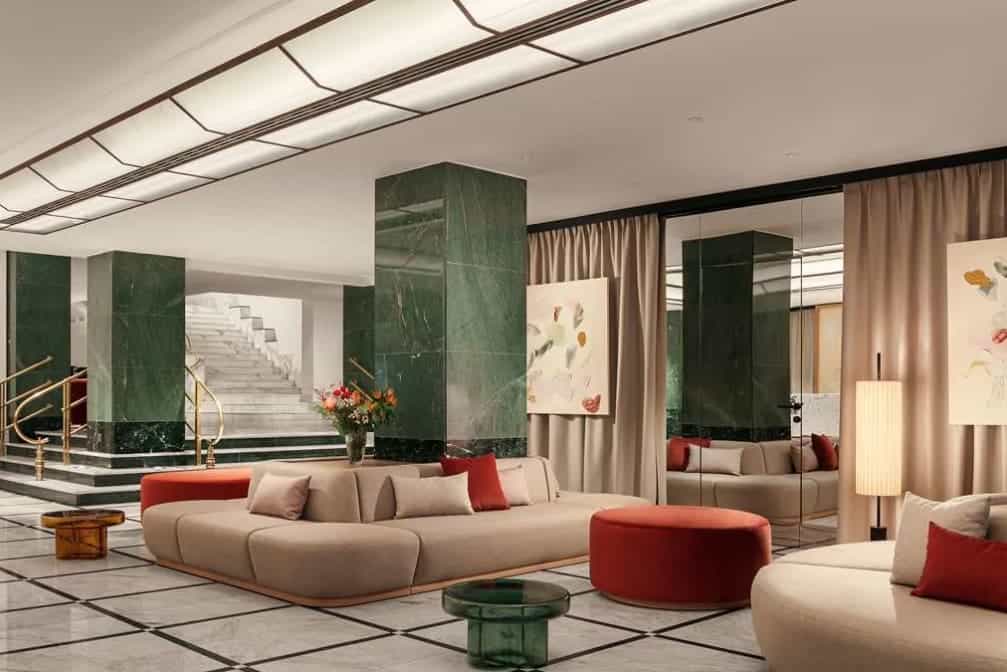 Hotel lobby area with green pillars, cream lounge seating and orange decoration