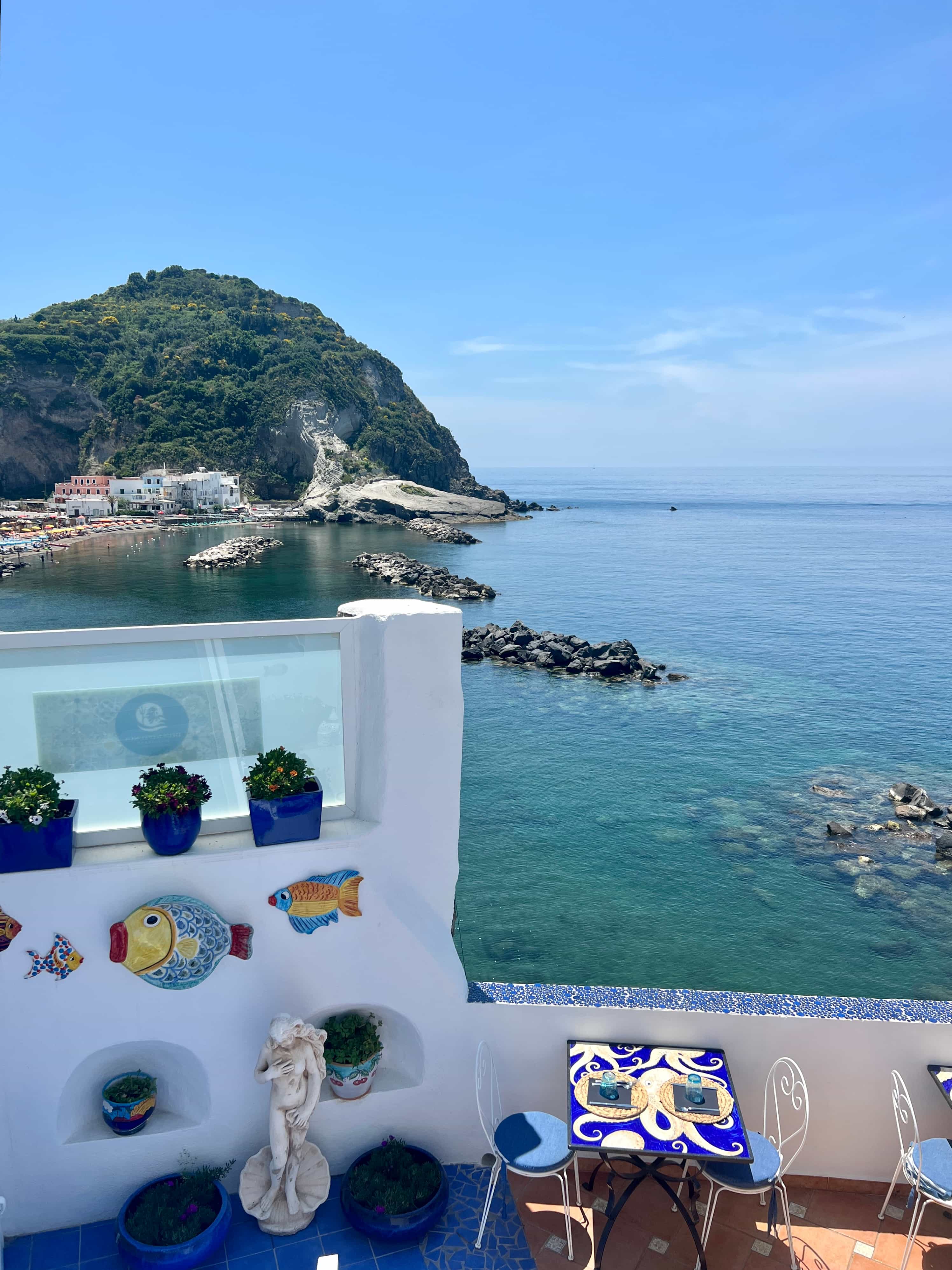 View of a rooftop balcony overlooking the sea and cliffs on a sunny day