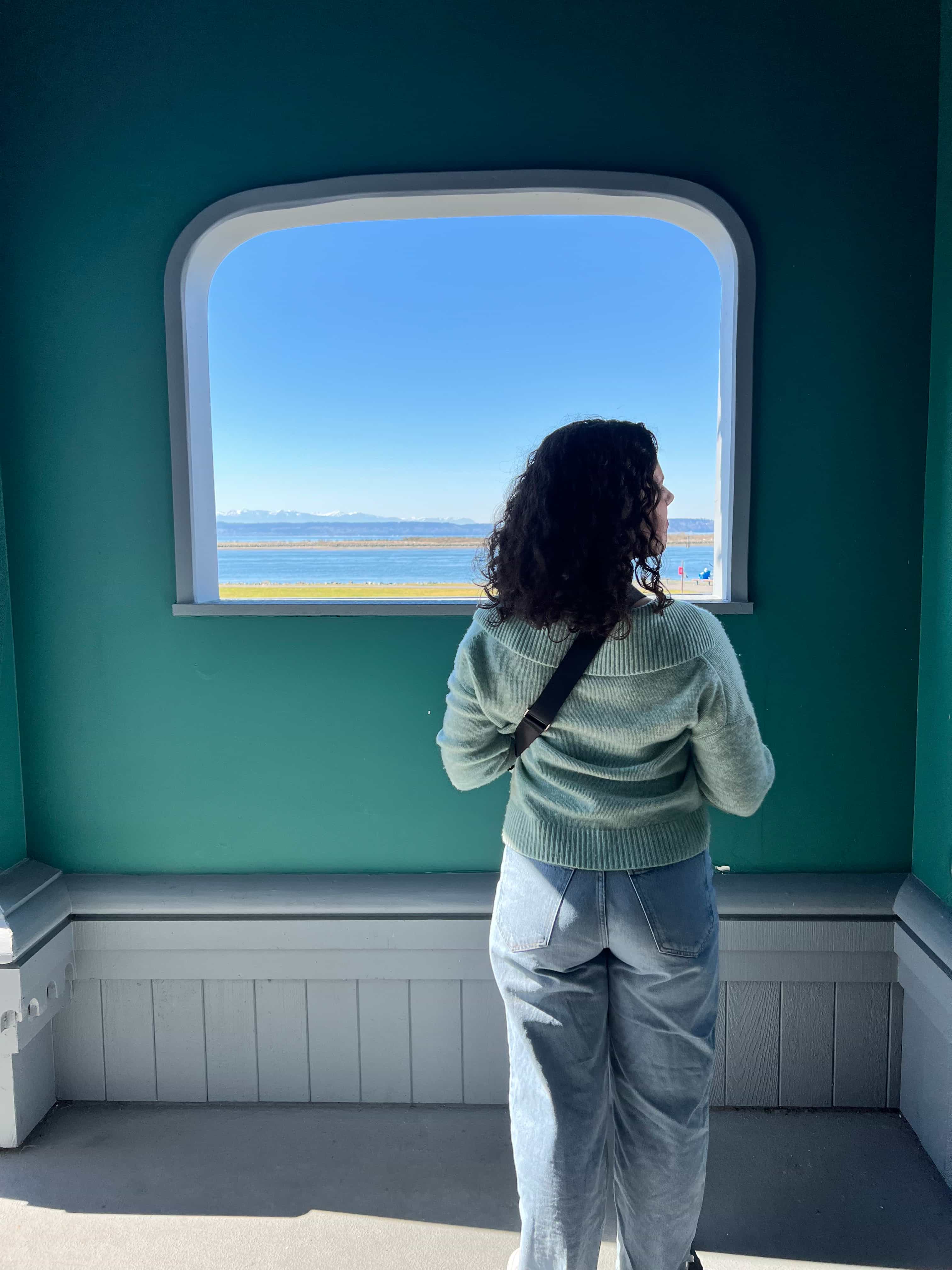 The back of an advisor looking out a window at a blue sky.