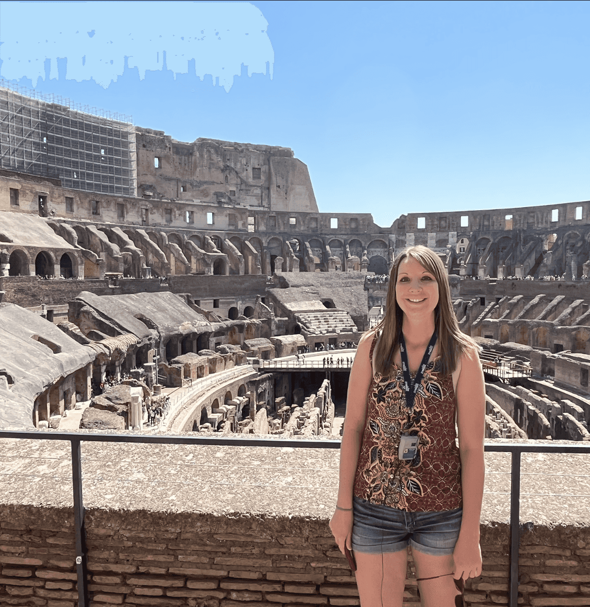 Advisor posing for an image with a coliseum in the background.