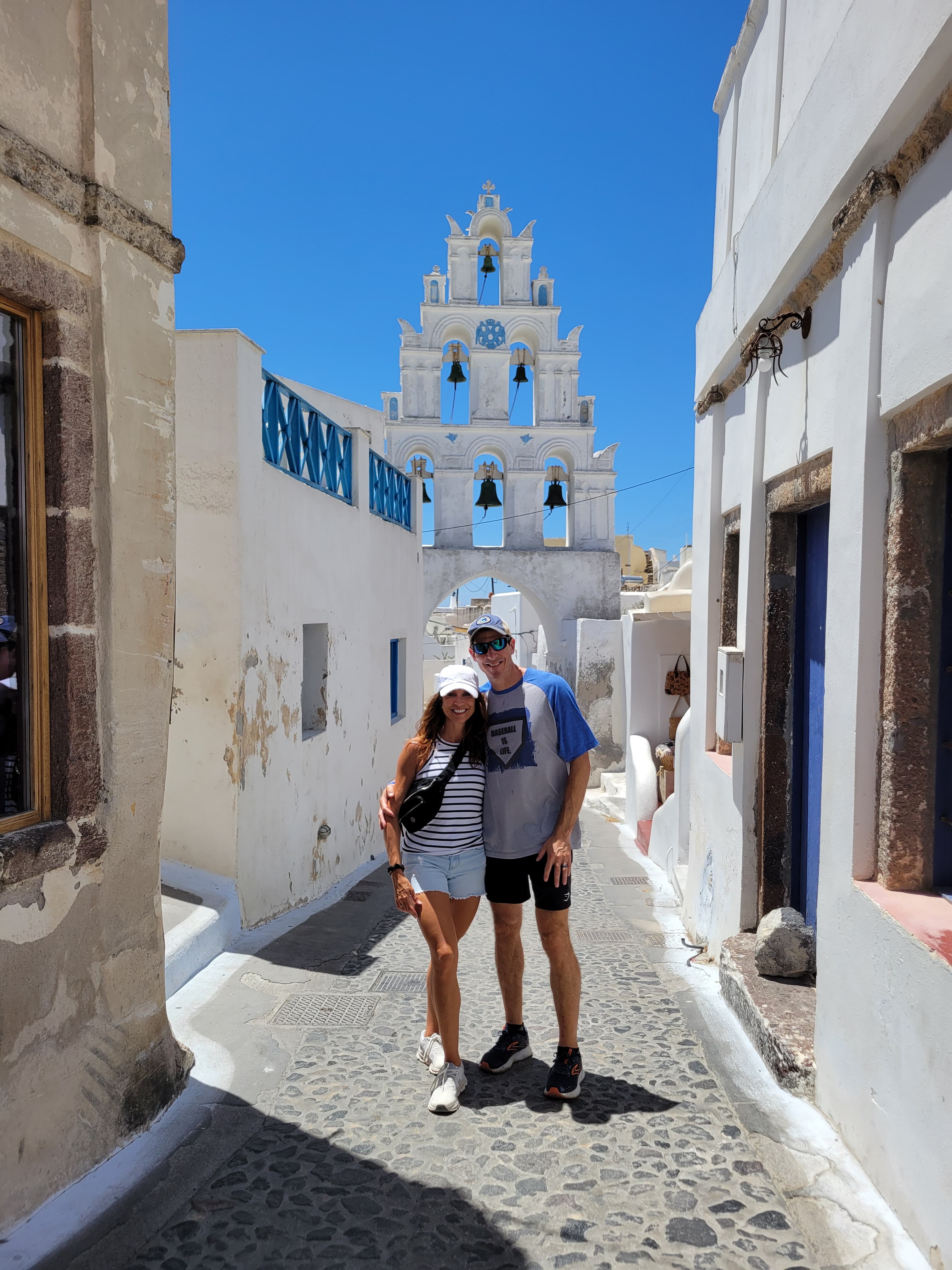 Travel advisor Laurie standing with male companion in a narrow street surrounding by white buildings.