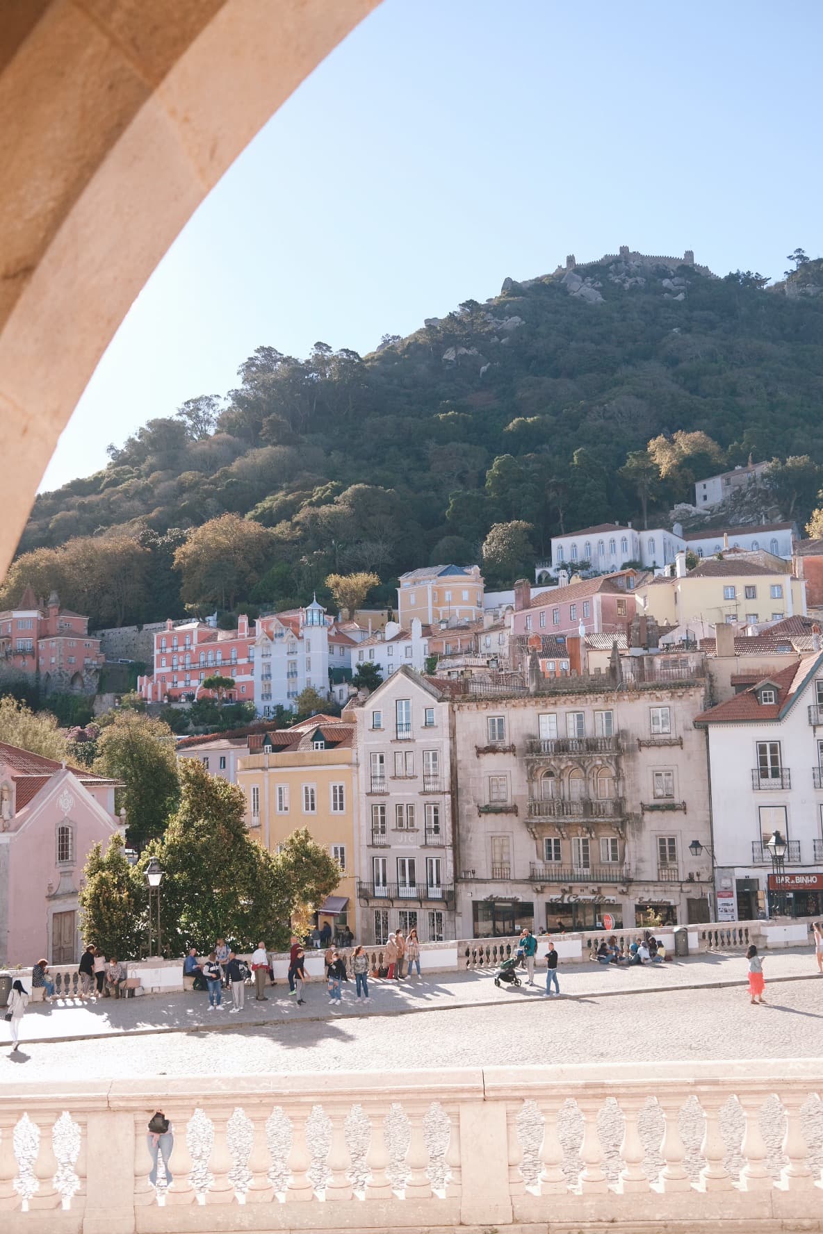 An image of a bustling town with mountains in the distance on a sunny day. 
