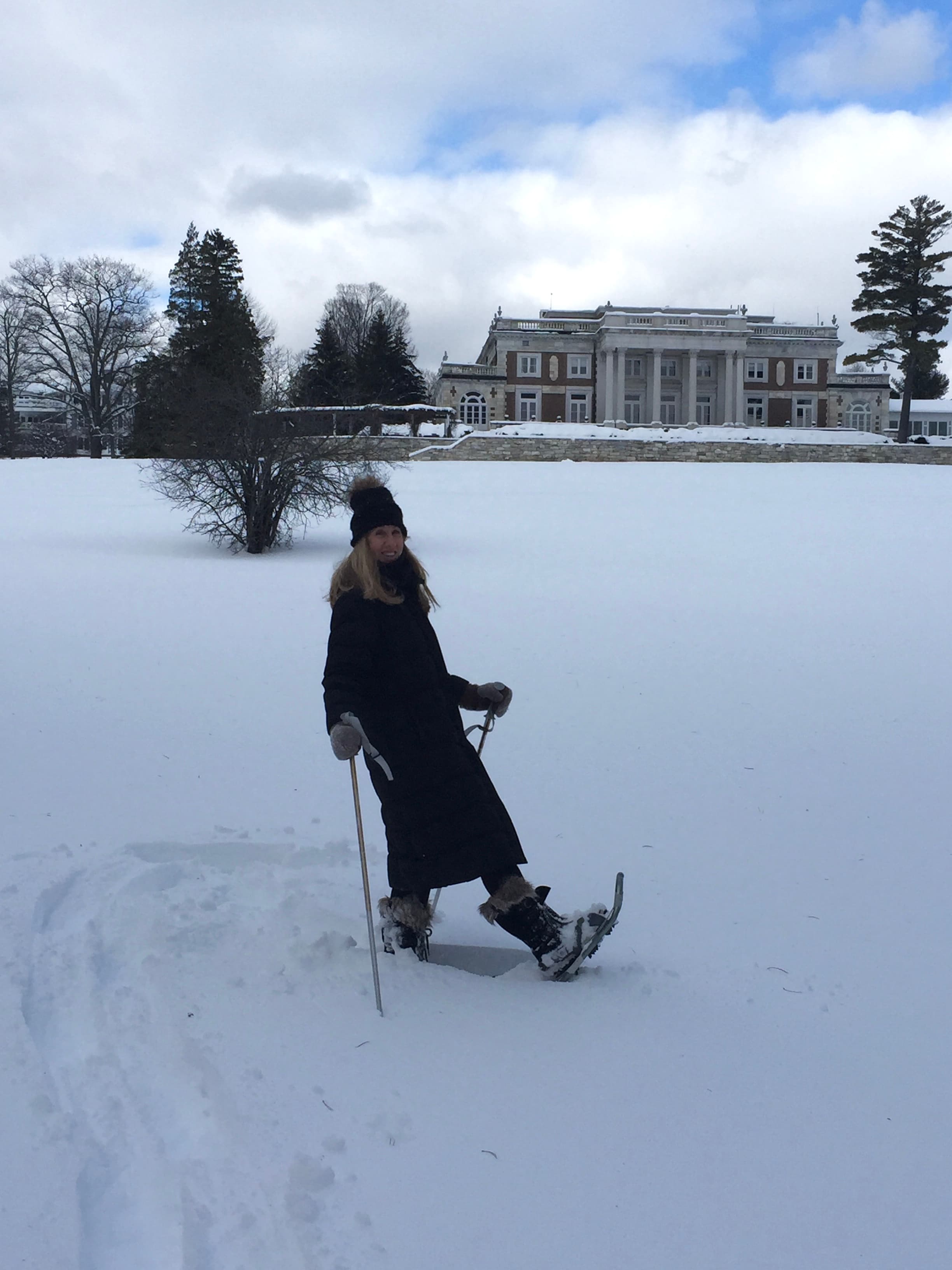 Advisor walking through a snowy field in snow shoes