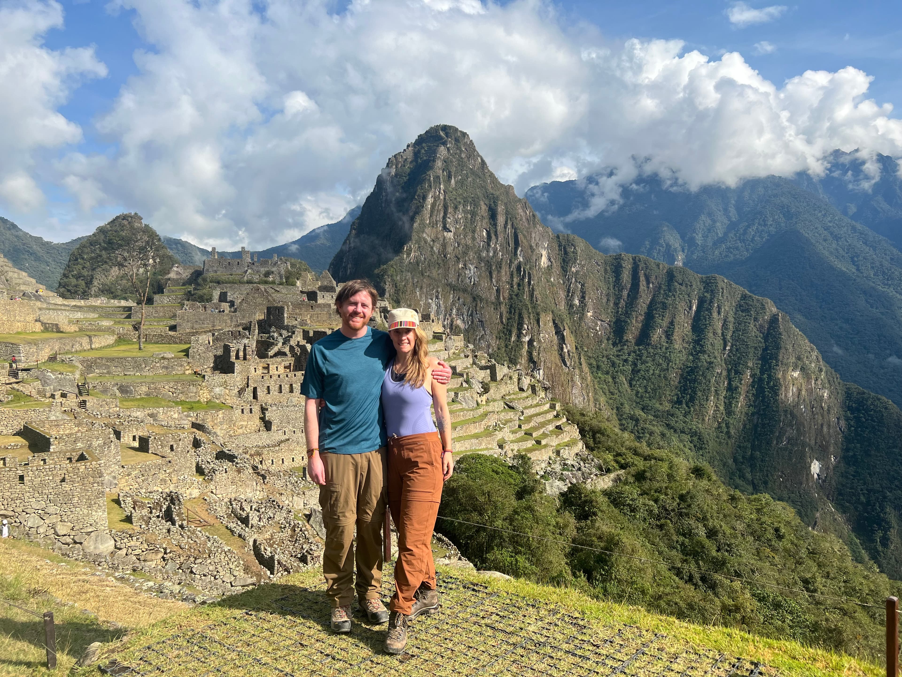 Advisor poses with her arm around a man in front of Machu Pichu