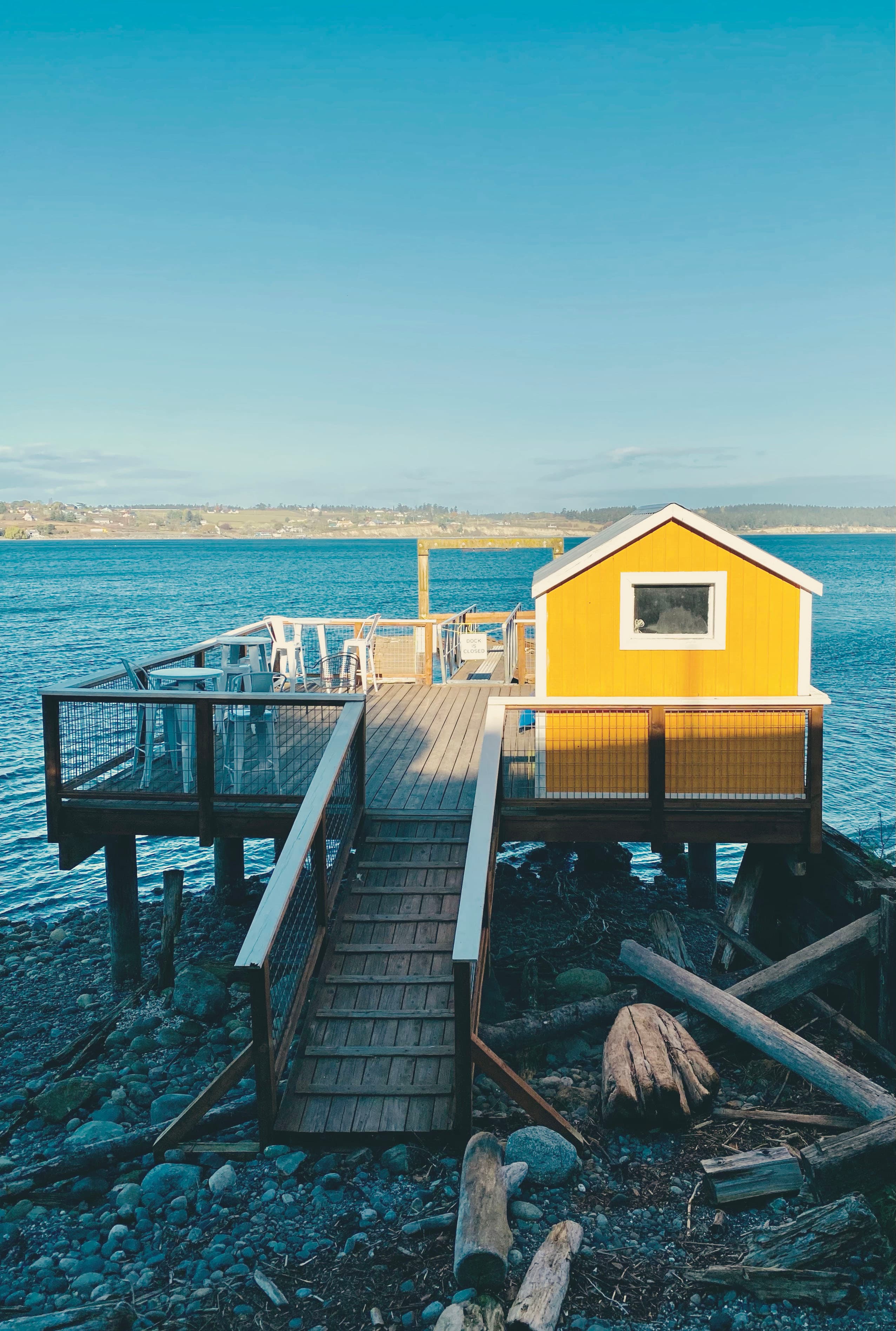 Pretty view of a square pier with a yellow building overlooking the sea on a sunny day