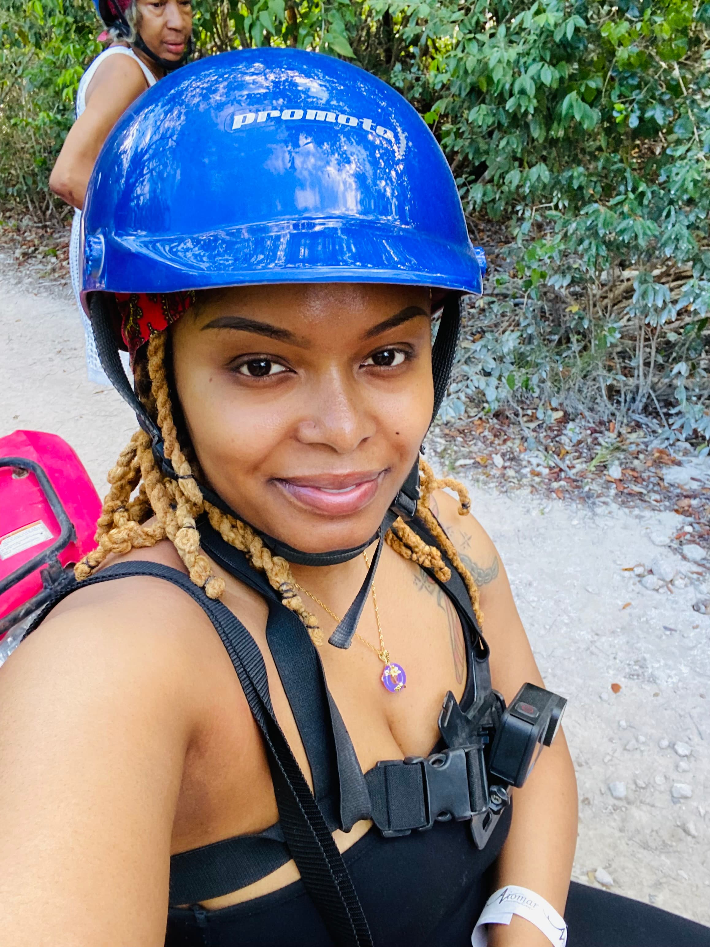 Ebony in a blue helmet taking a selfie outdoors