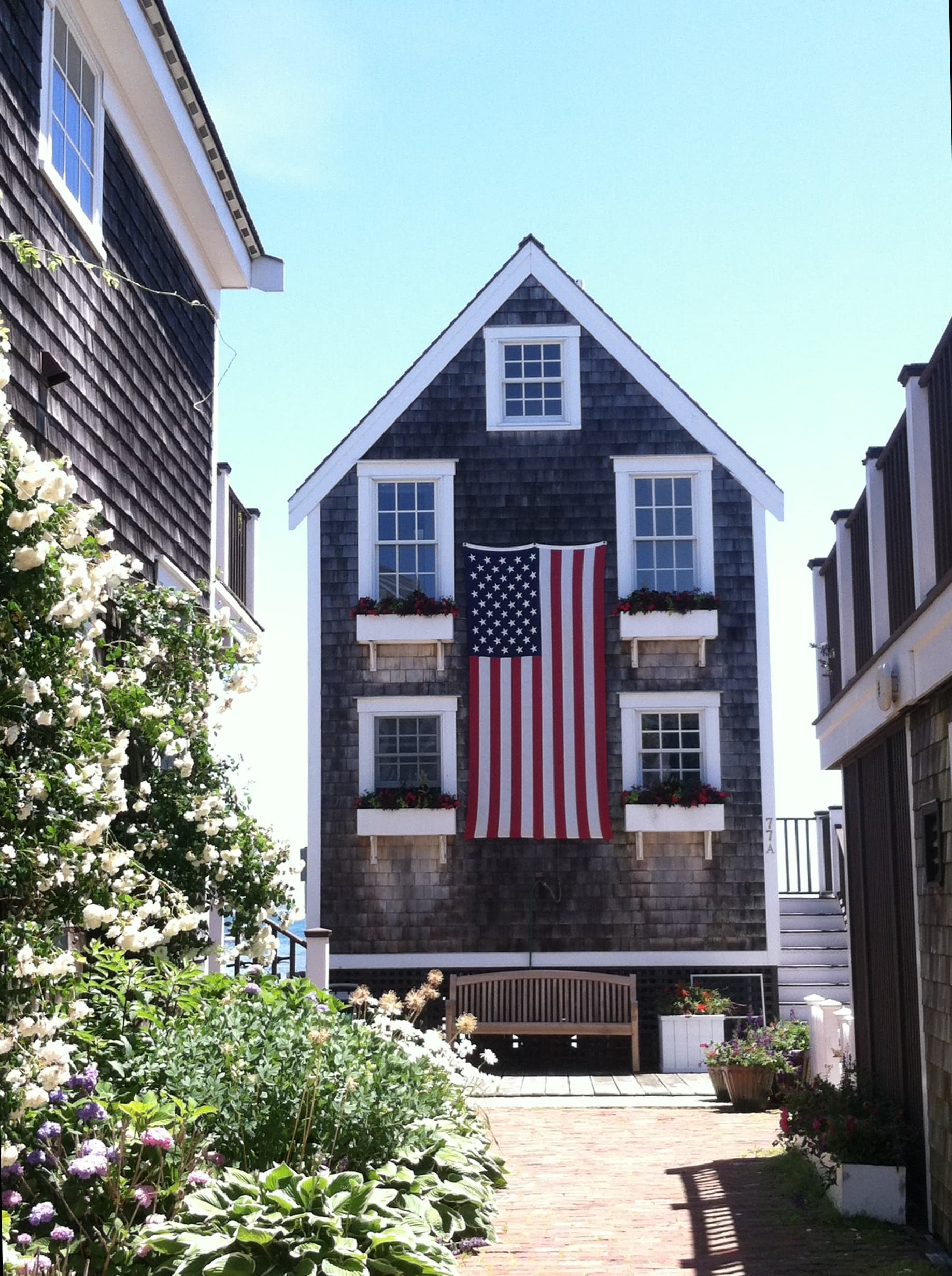 View of a small building with an American flag hung out front on a sunny day