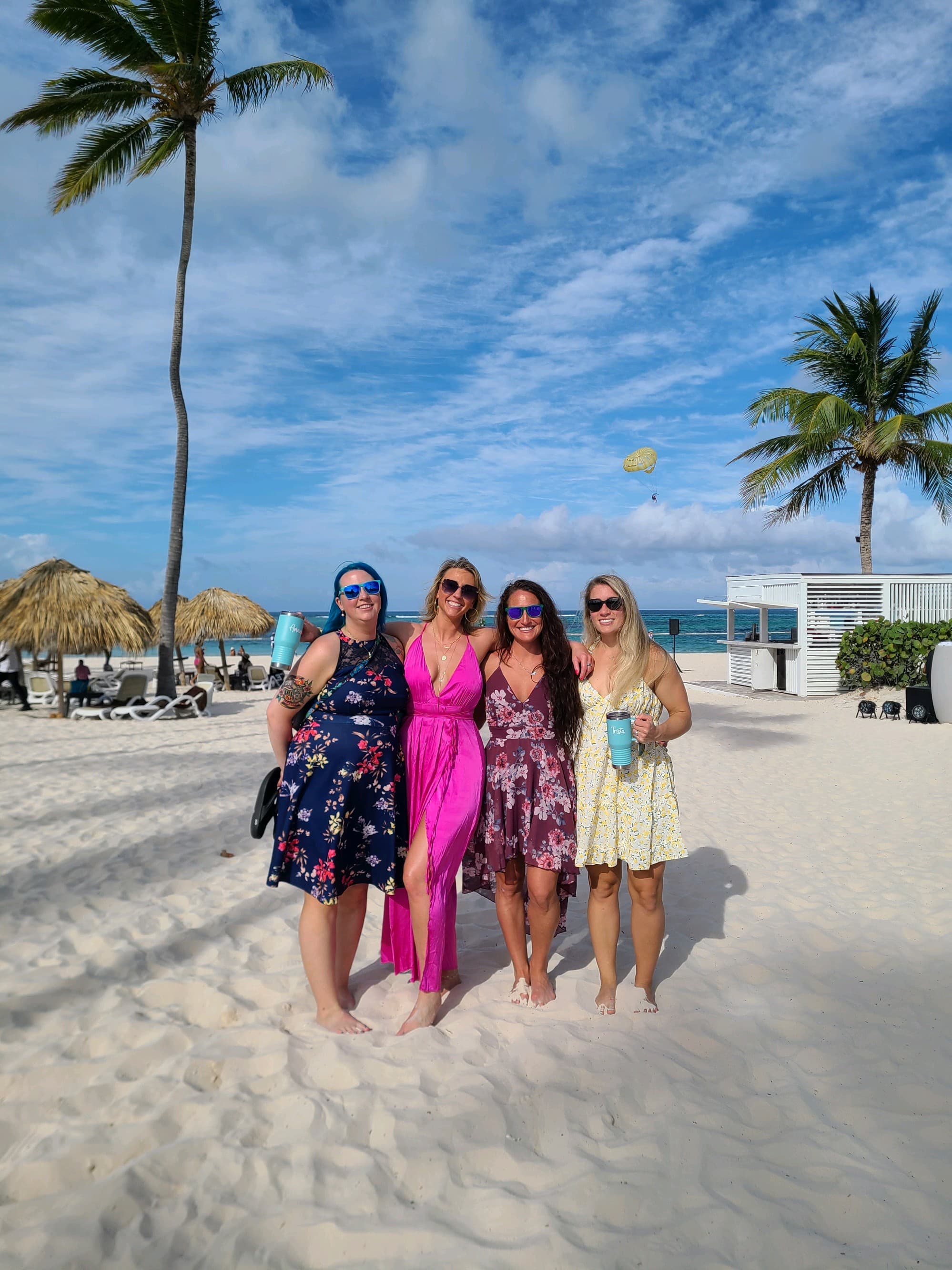 A group of girls posing for an photo on the beach.