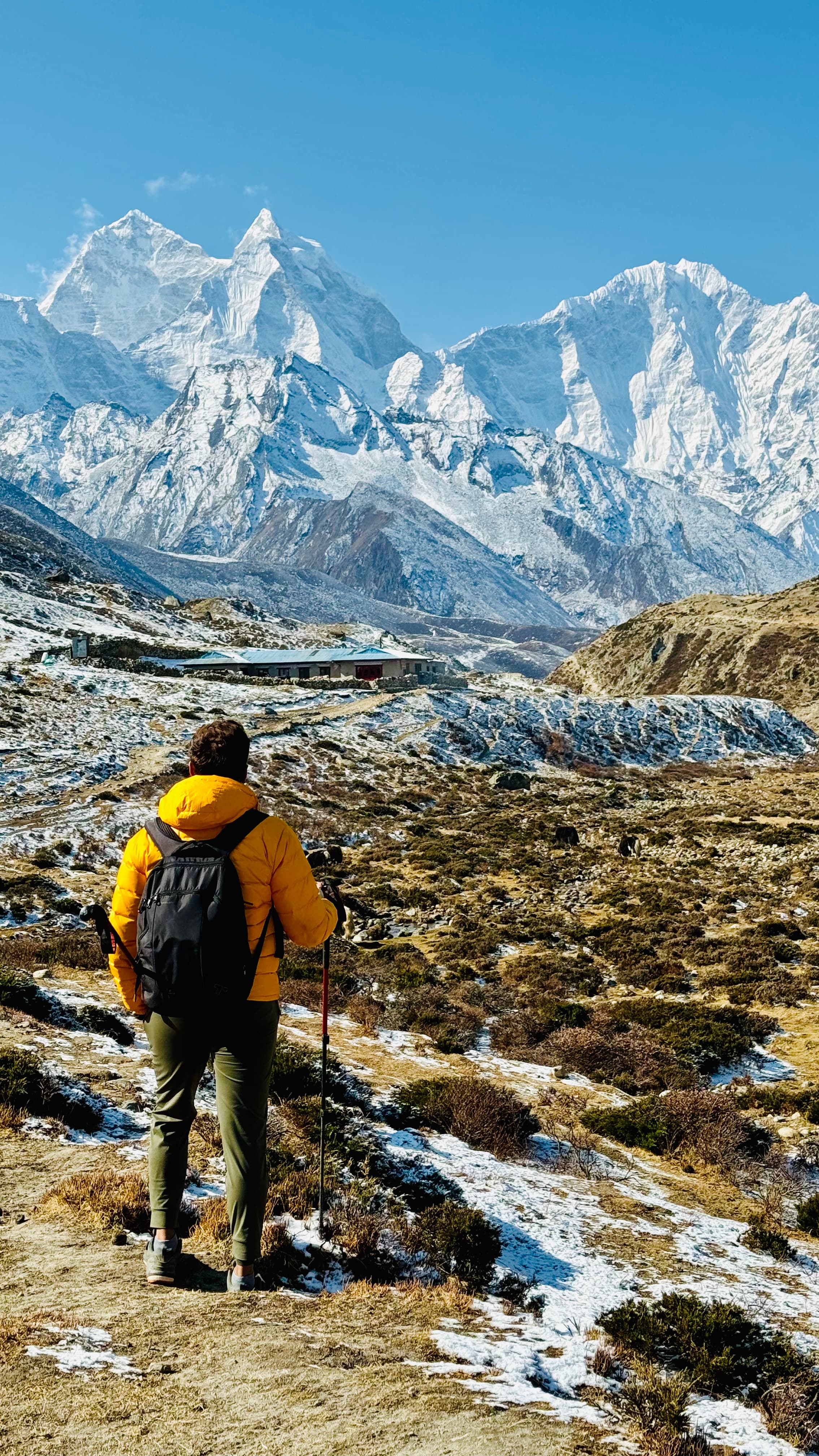 Beautiful view of advisor hiking through a valley with huge snowy mountains in the distance
