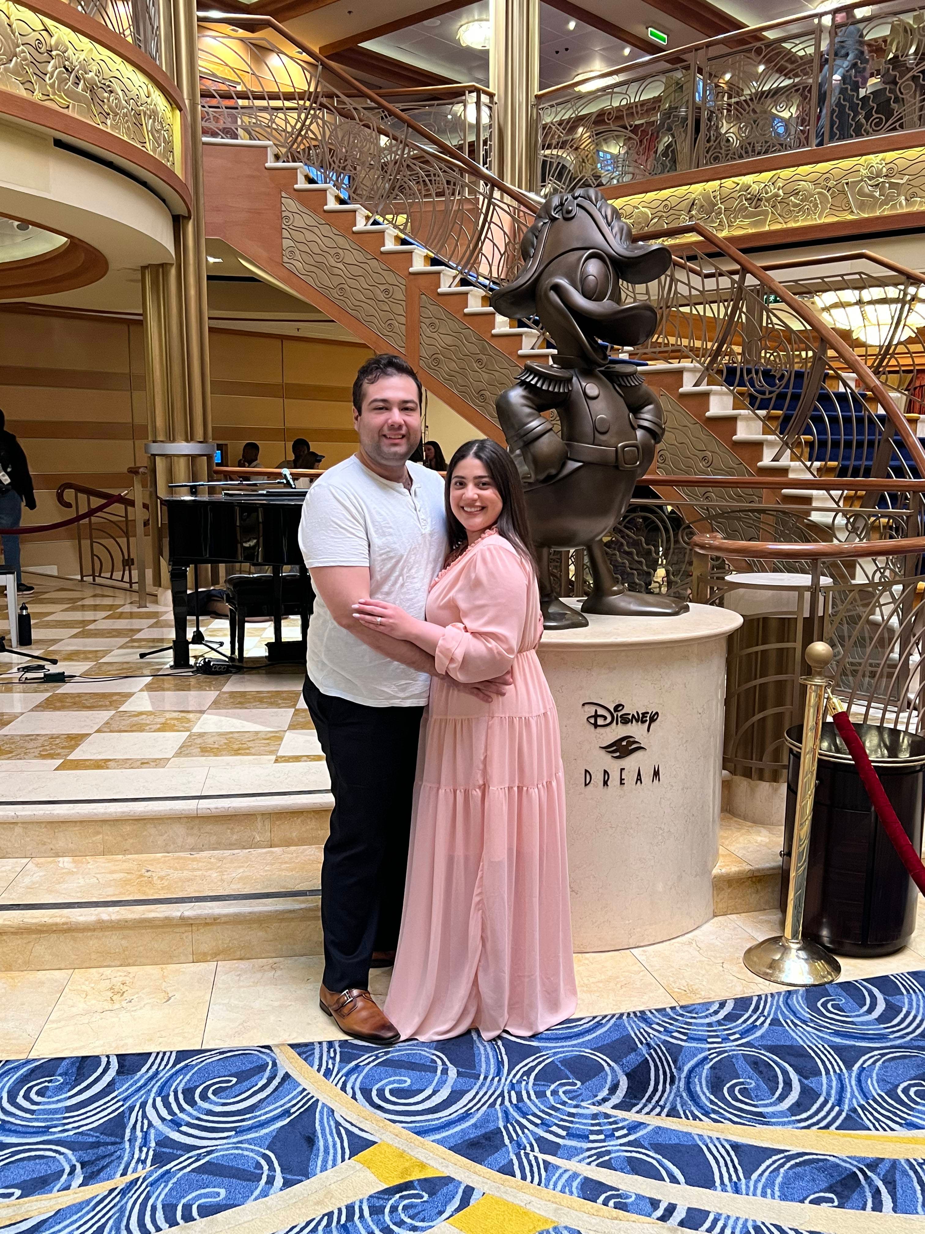Man and woman below decorative stairs.