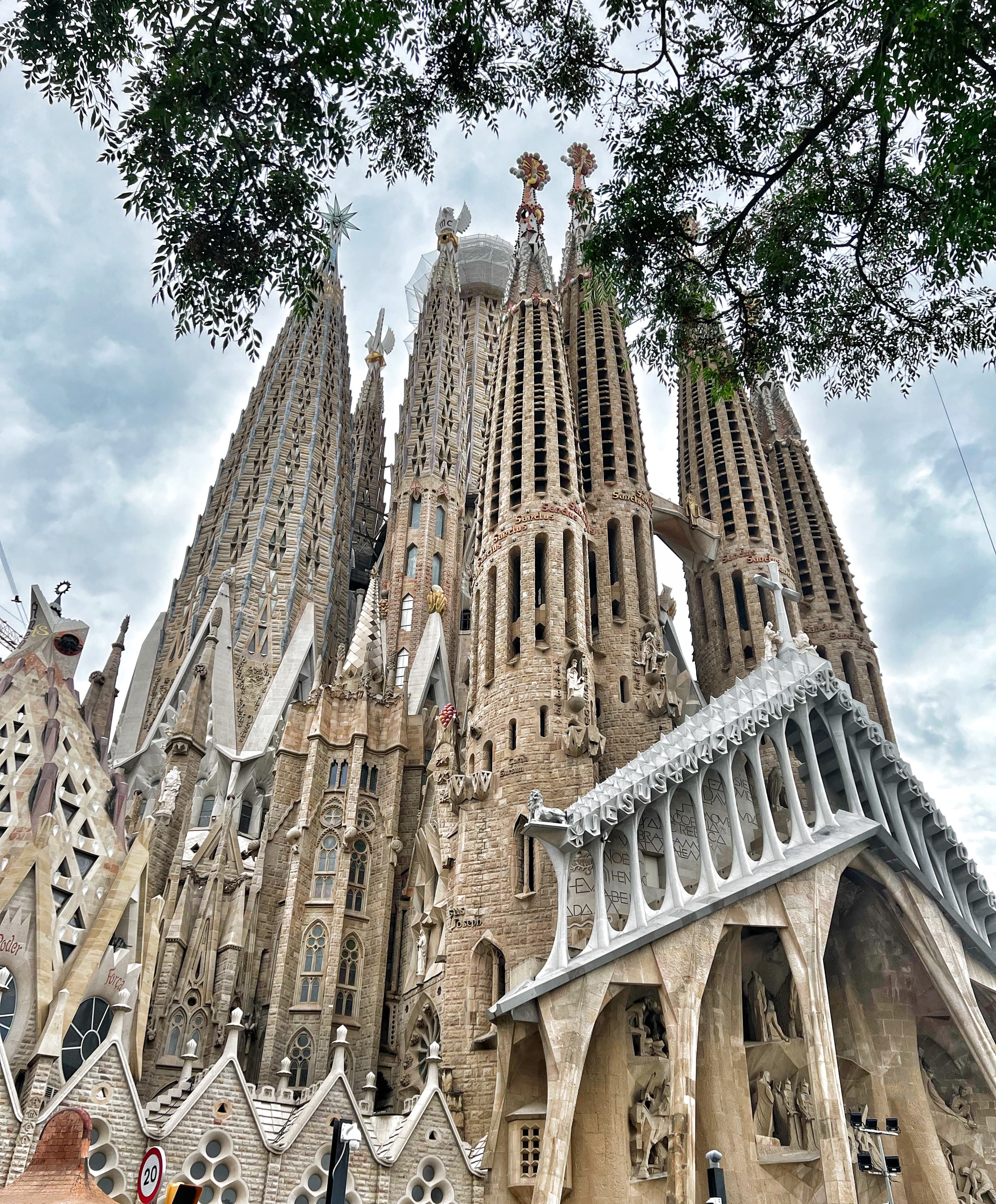 View of the Sagrada Familia reaching toward the sky on a cloudy day. 
