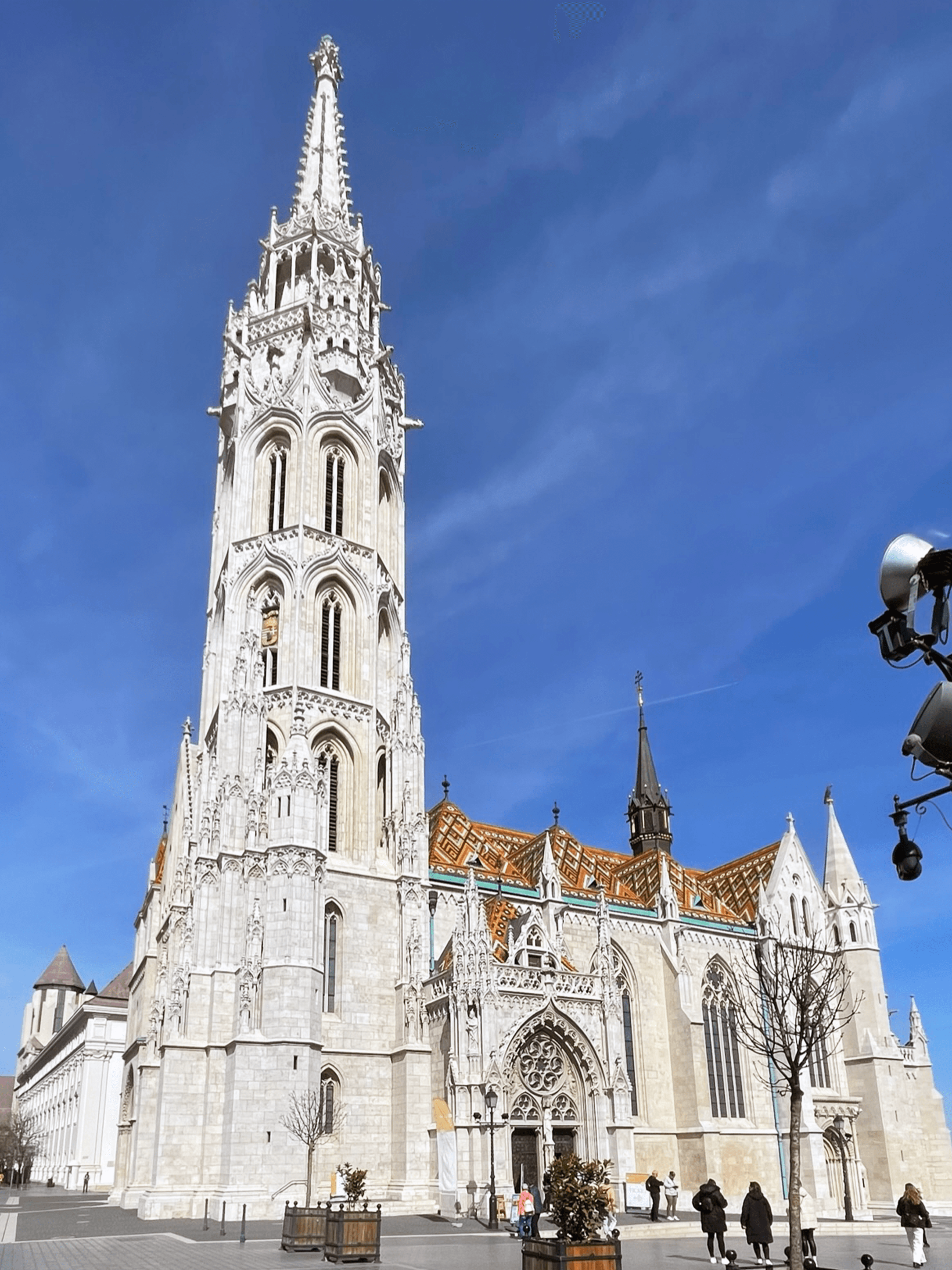 View of a cathedral and pedestrians walking nearby on a sunny day