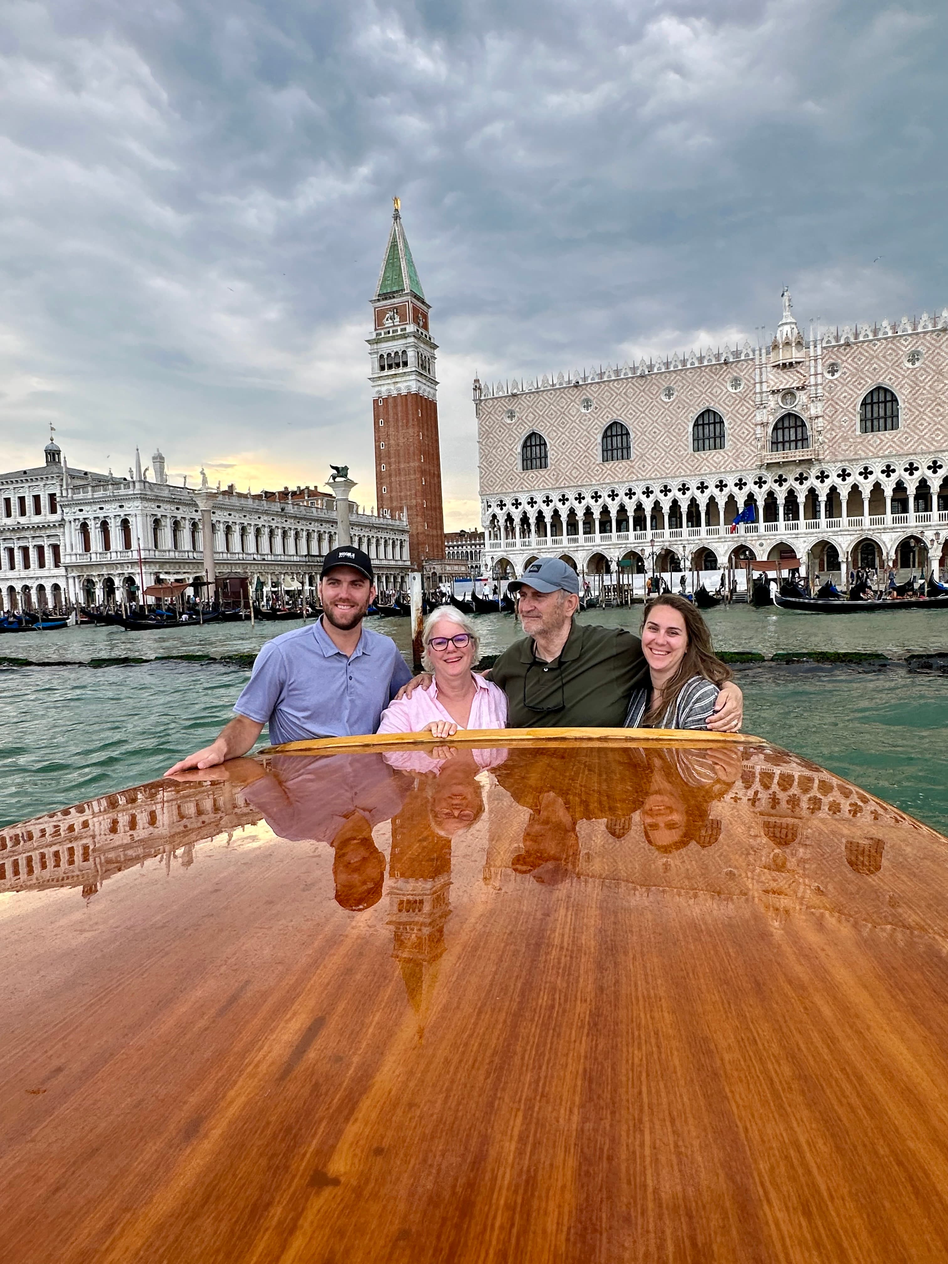 Angie and family sitting together with a view of tall buildings and water in the background.