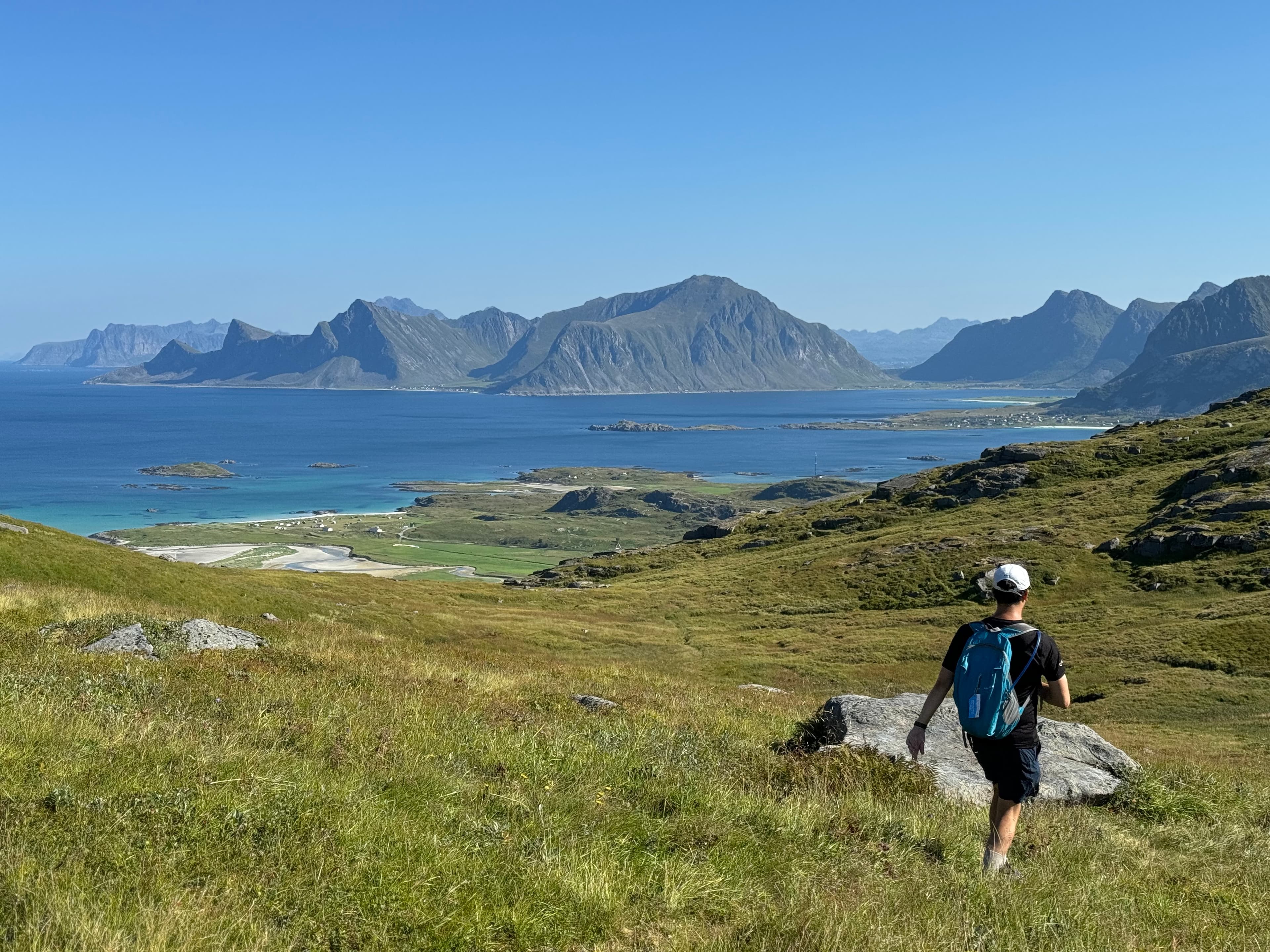 View of advisor on a hike through a beautiful grassy area overlooking the sea and mountains