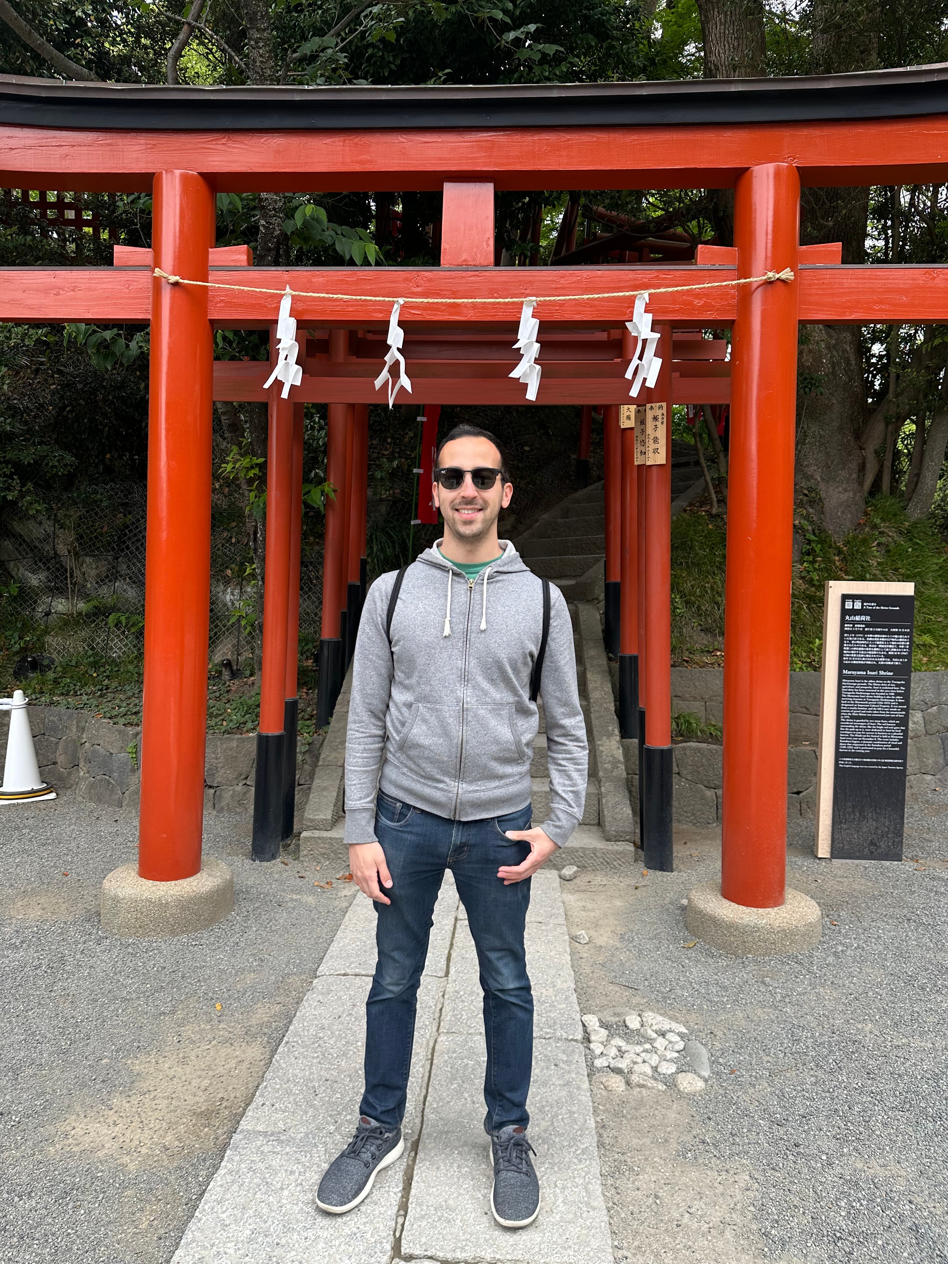 Advisor posing beneath a red Japanese temple structure