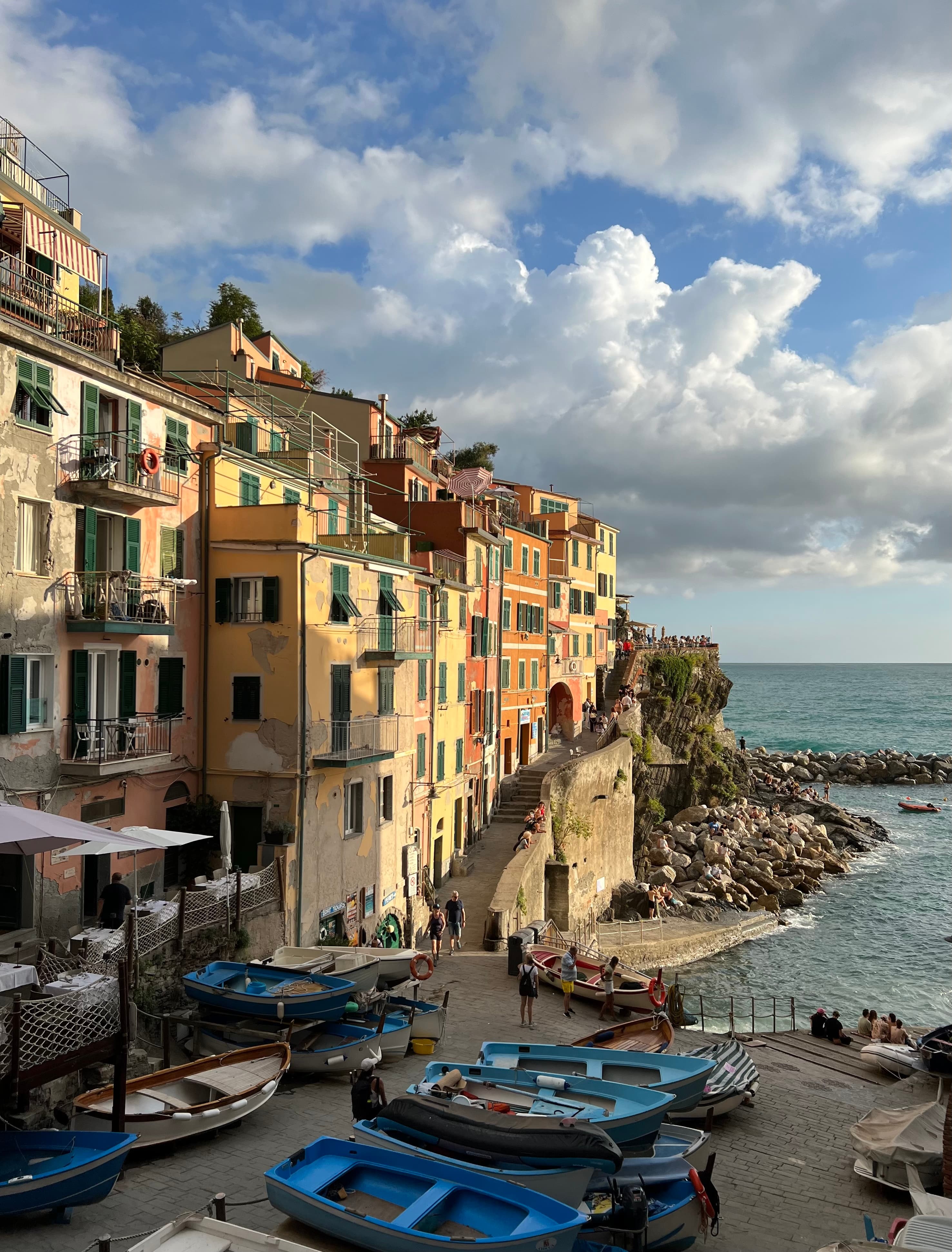 A seaside town glistens in the dusk light as waves gently lap the shore. 