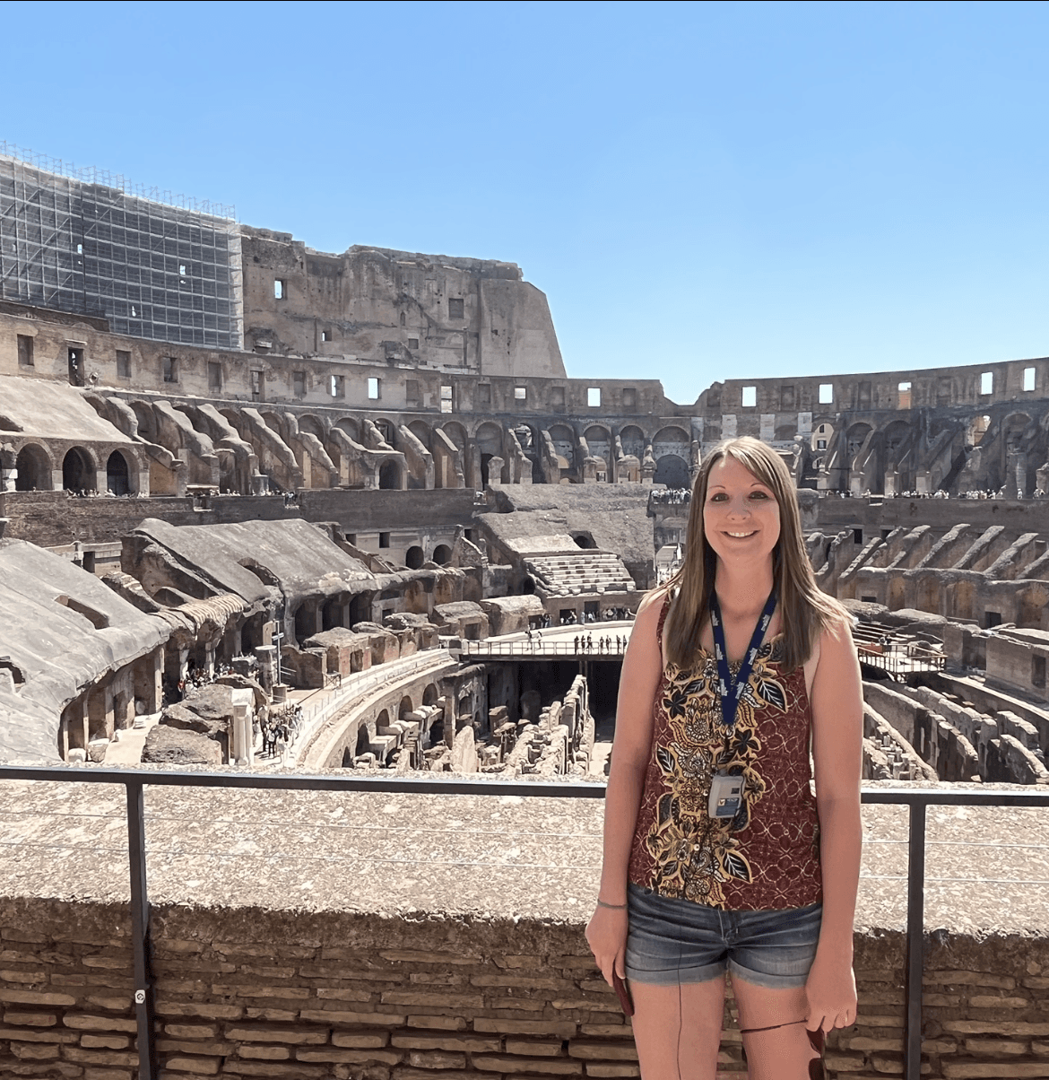 Advisor posing for an image with a coliseum in the background.