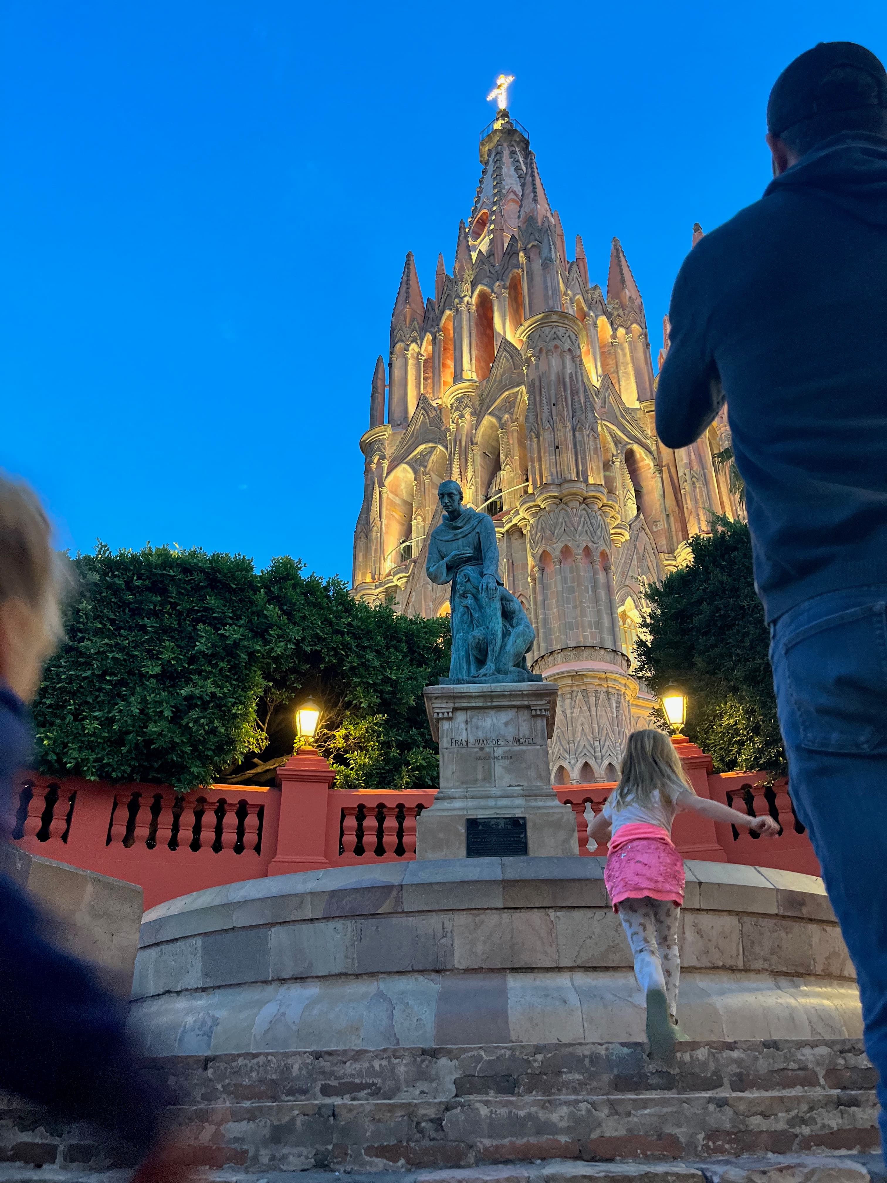 Advisor posing on steps  at dusk with the cathedral of San Miguel de Allende lit up behind her
