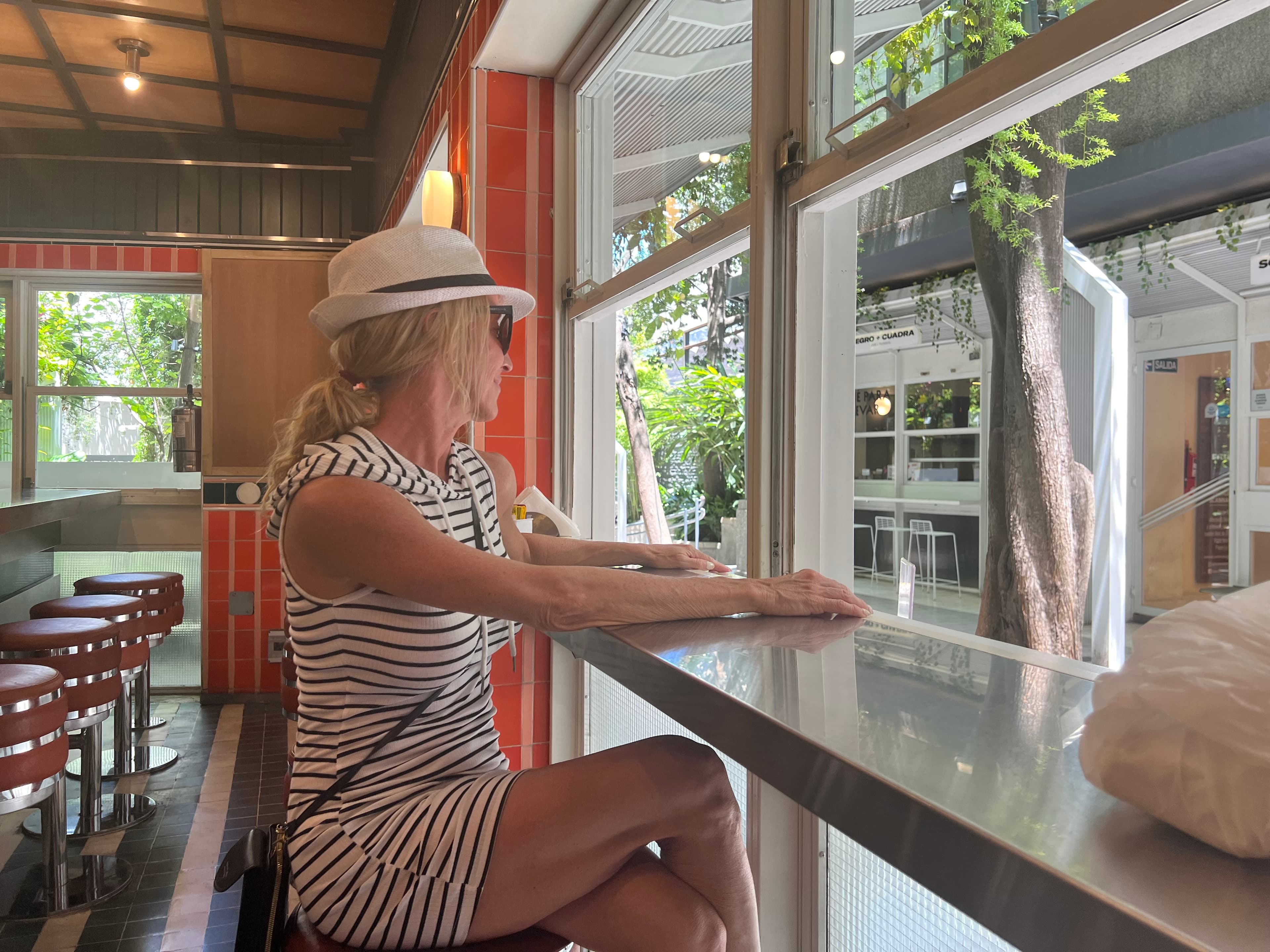 Jennifer posing at a bar in a restaurant during the daytime.