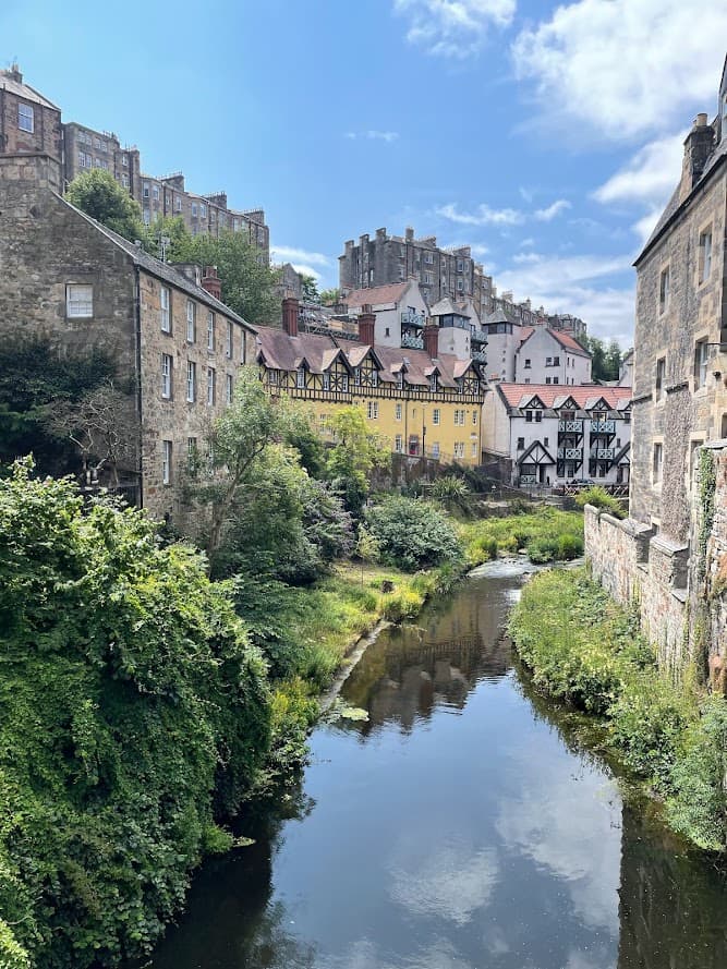 A river flows through a city, flanked by buildings on both sides, showcasing urban life and natural beauty.