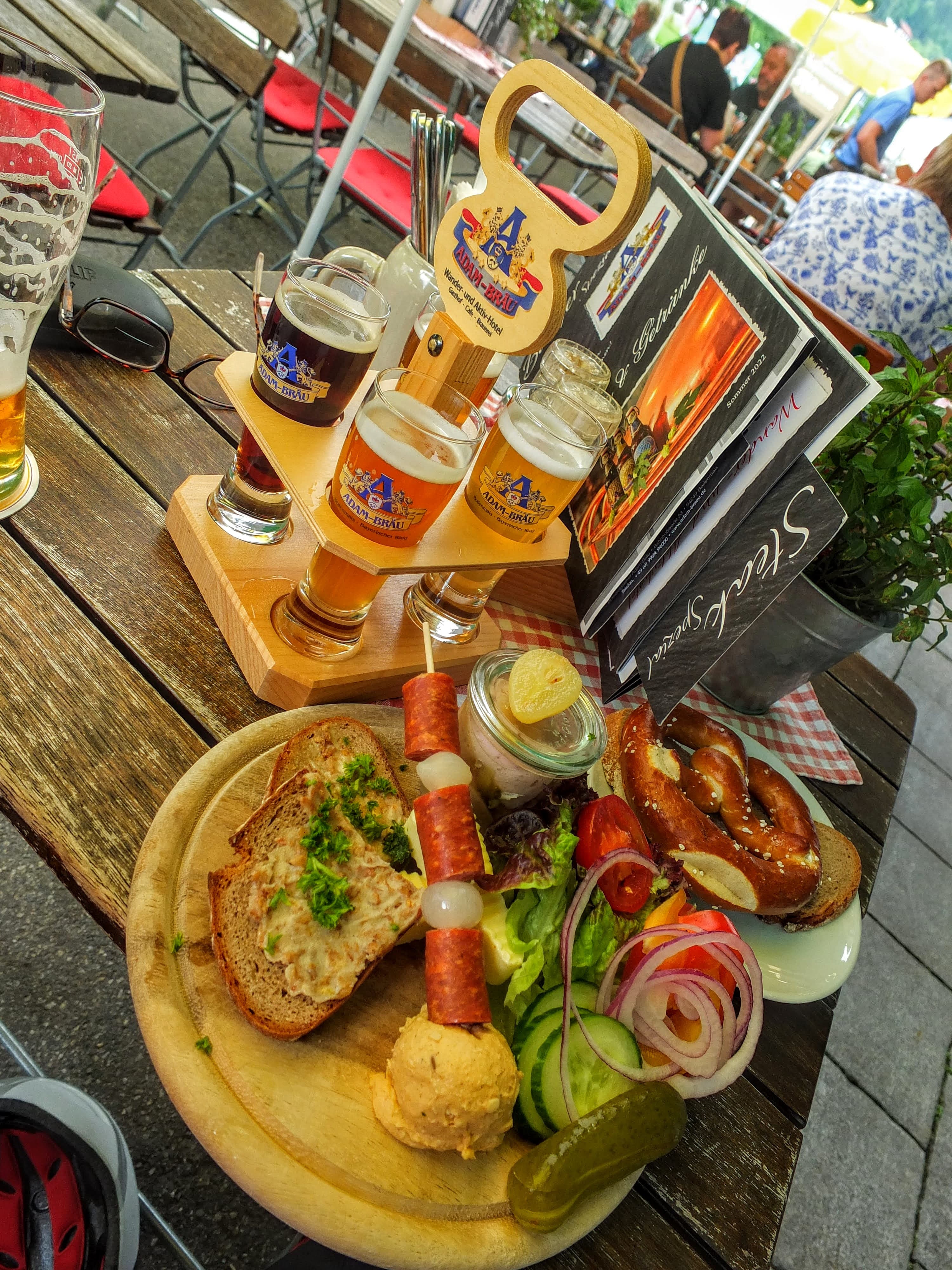 A food view with yellow tables, glasses of beer and menus on a wooden table.