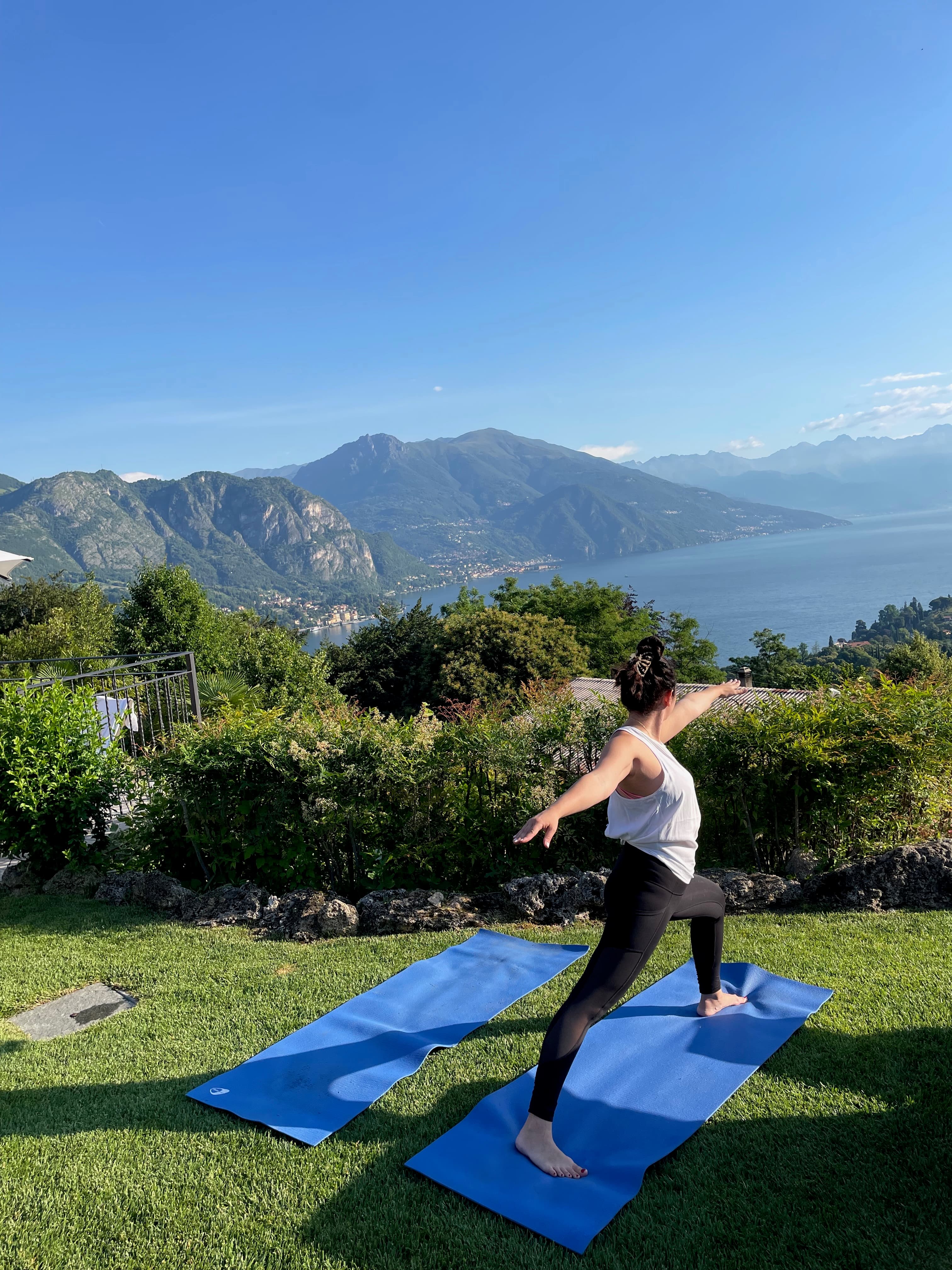 Advisor doing yoga in a grassy area overlooking a beautiful coastline