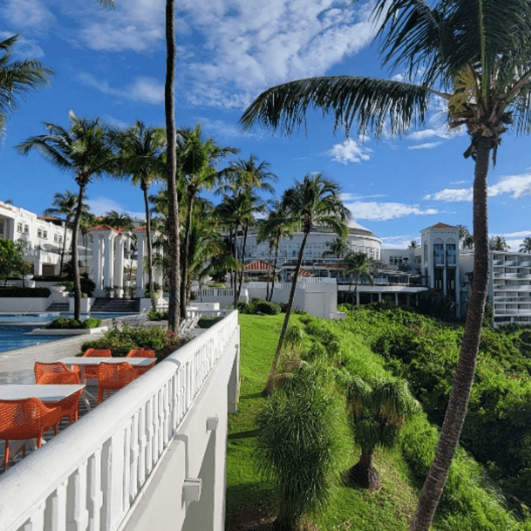 View of gardens and palm trees at a resort on a sunny day