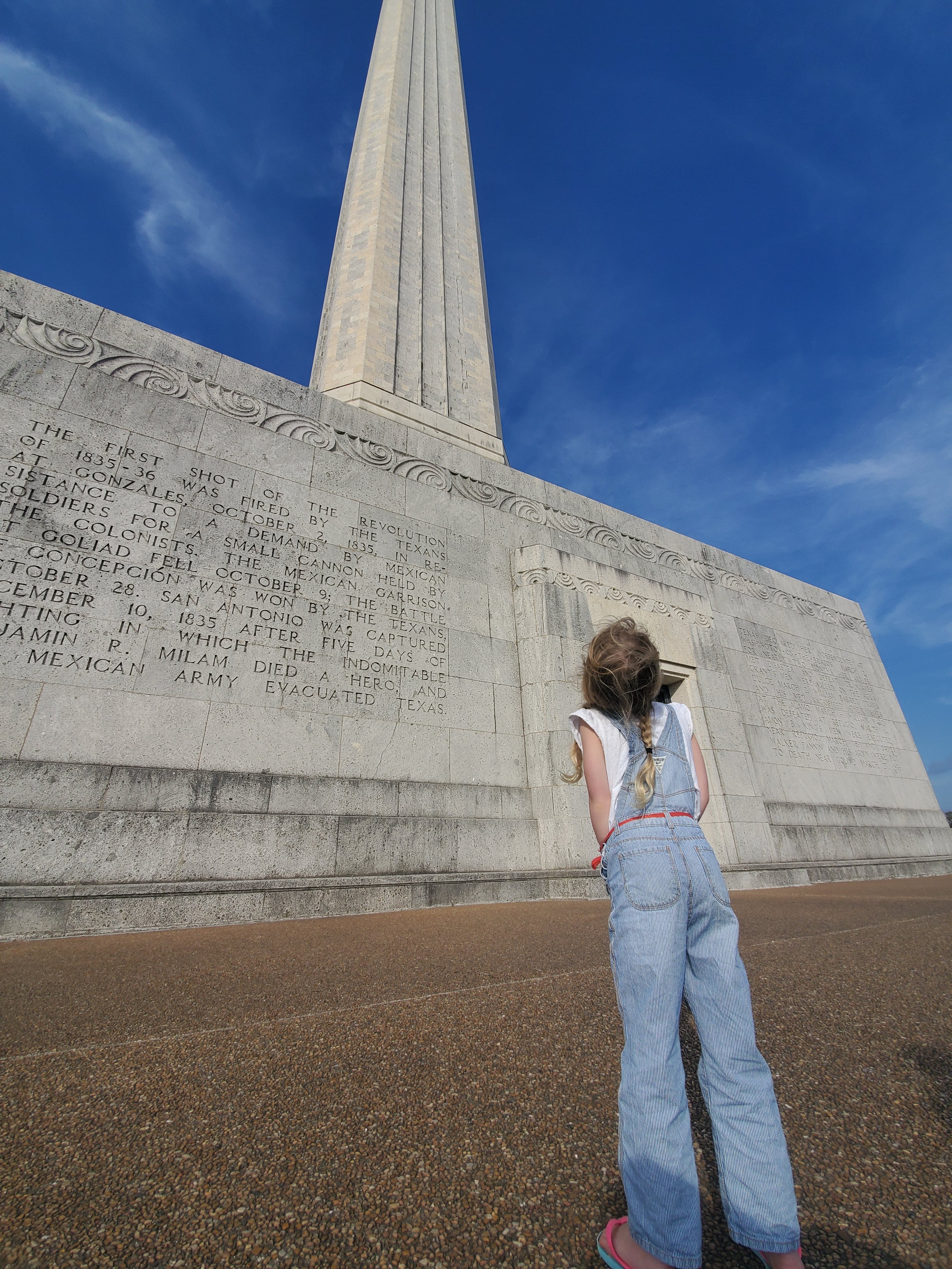 Advisor’s daughter looking up at a massive white column on a sunny day