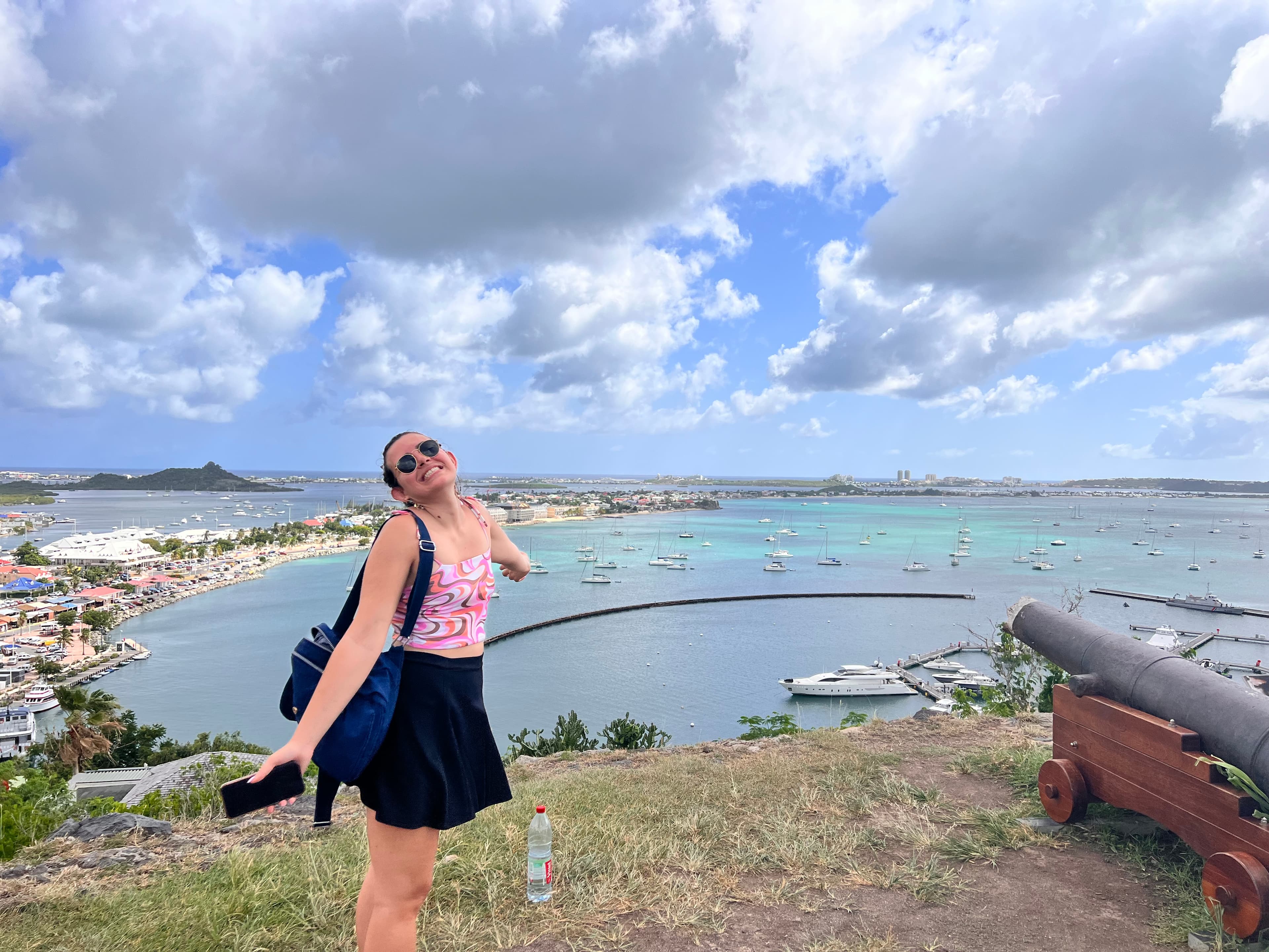 Lauren posing with open arms in pink top and short skirt