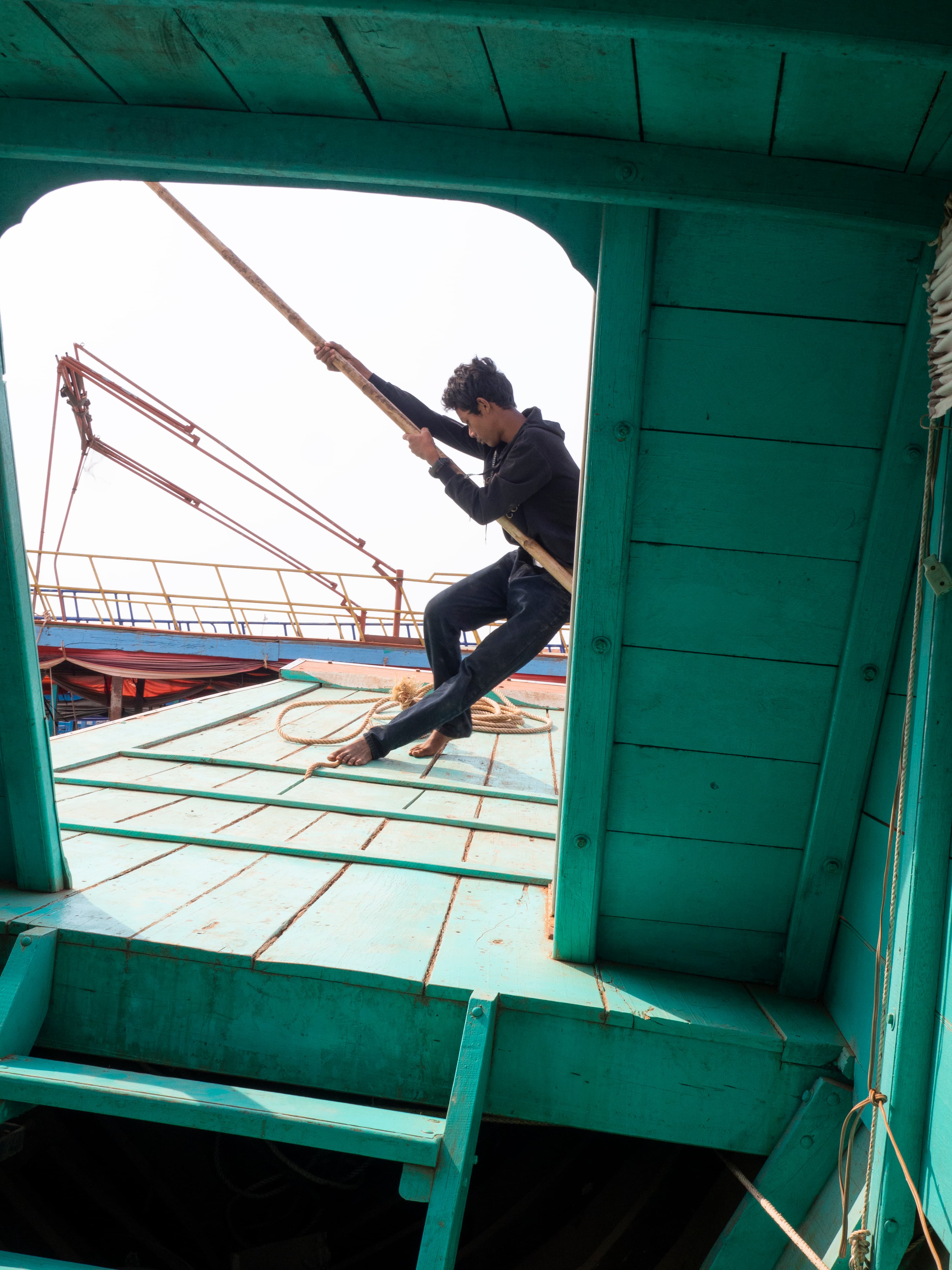 Man pulling the sails of a ship