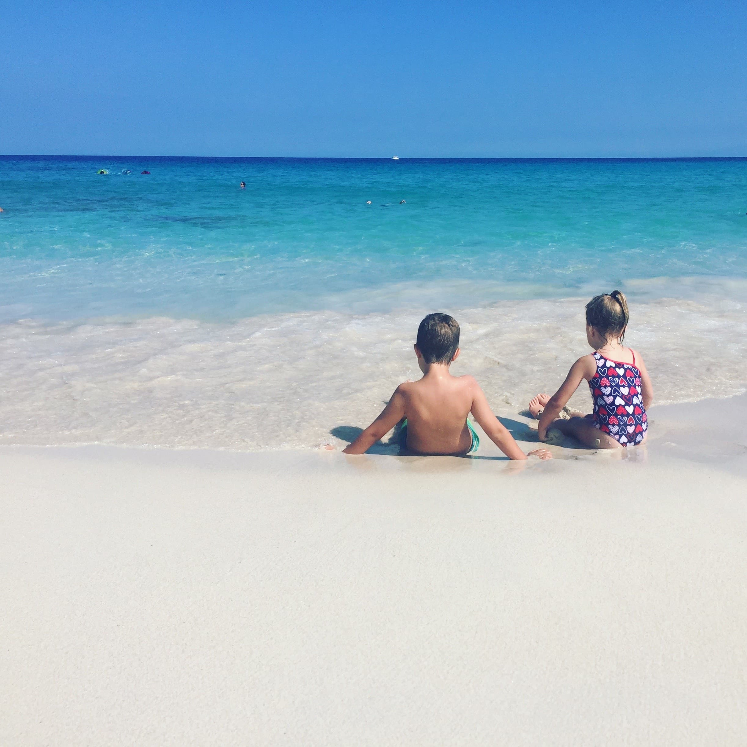 Kids playing on a beach.