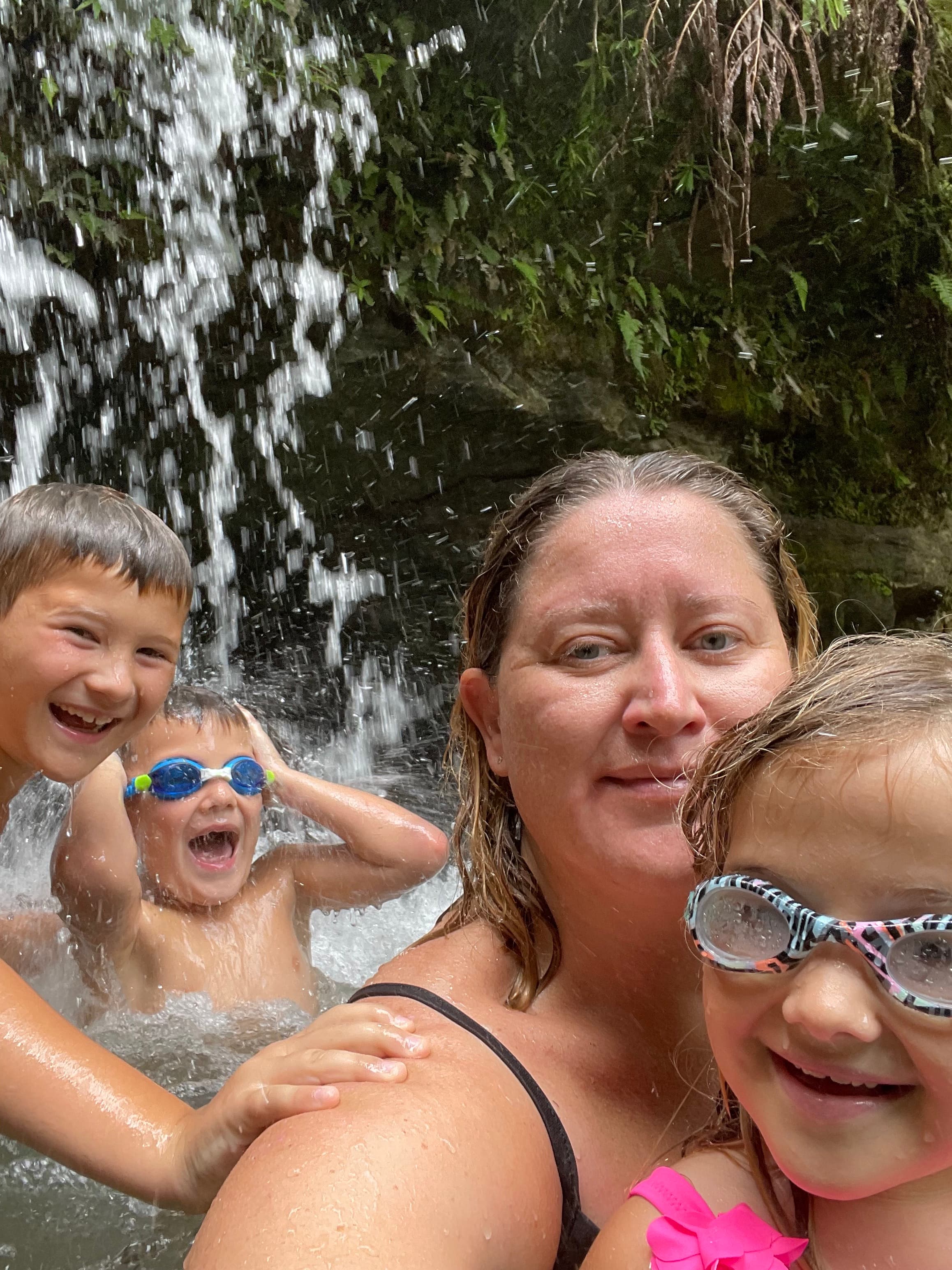 Karyn swimming in a lovely waterfall area with her kids.