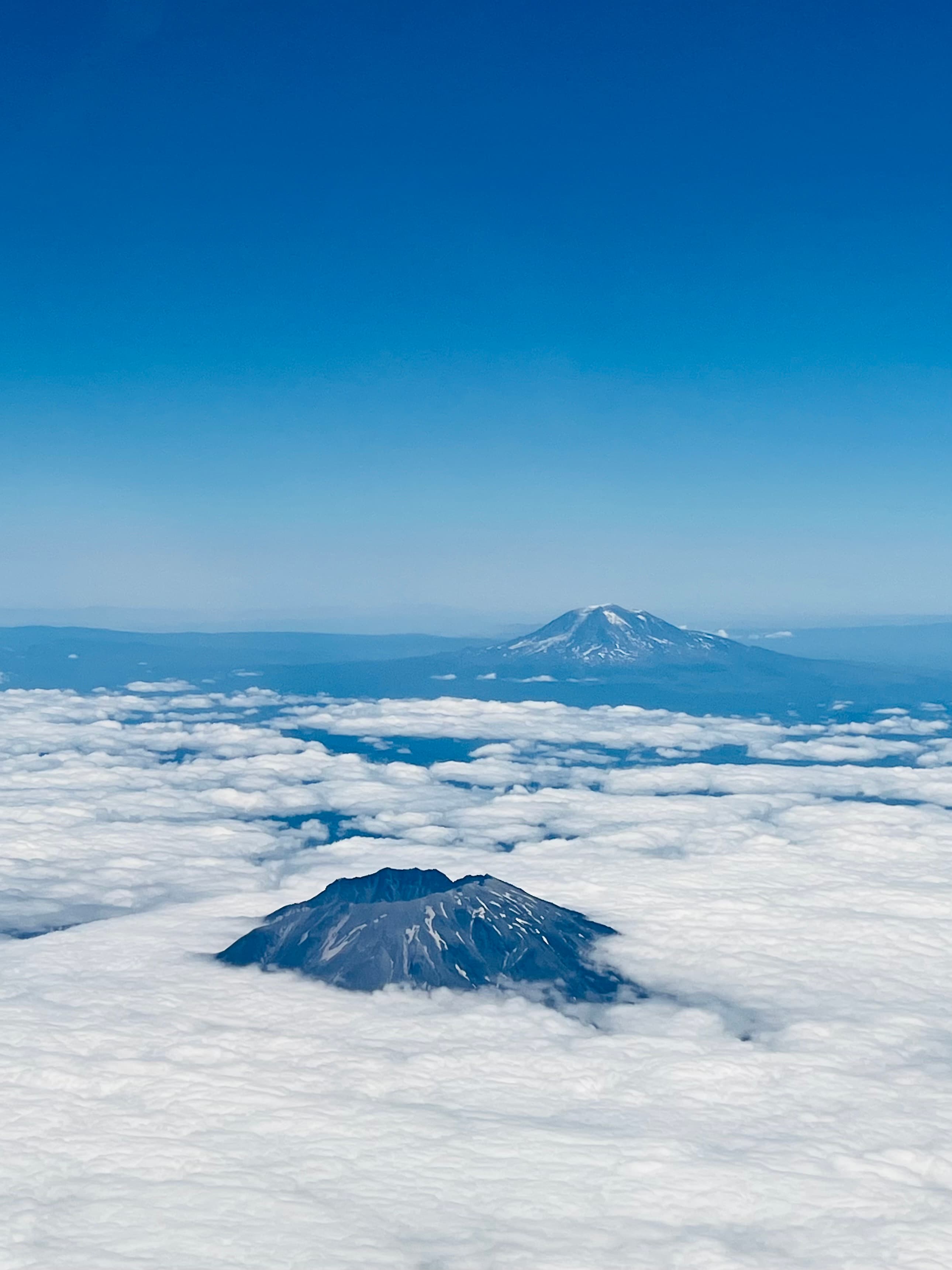 An elevated view of mountain ranges and clouds from high up.