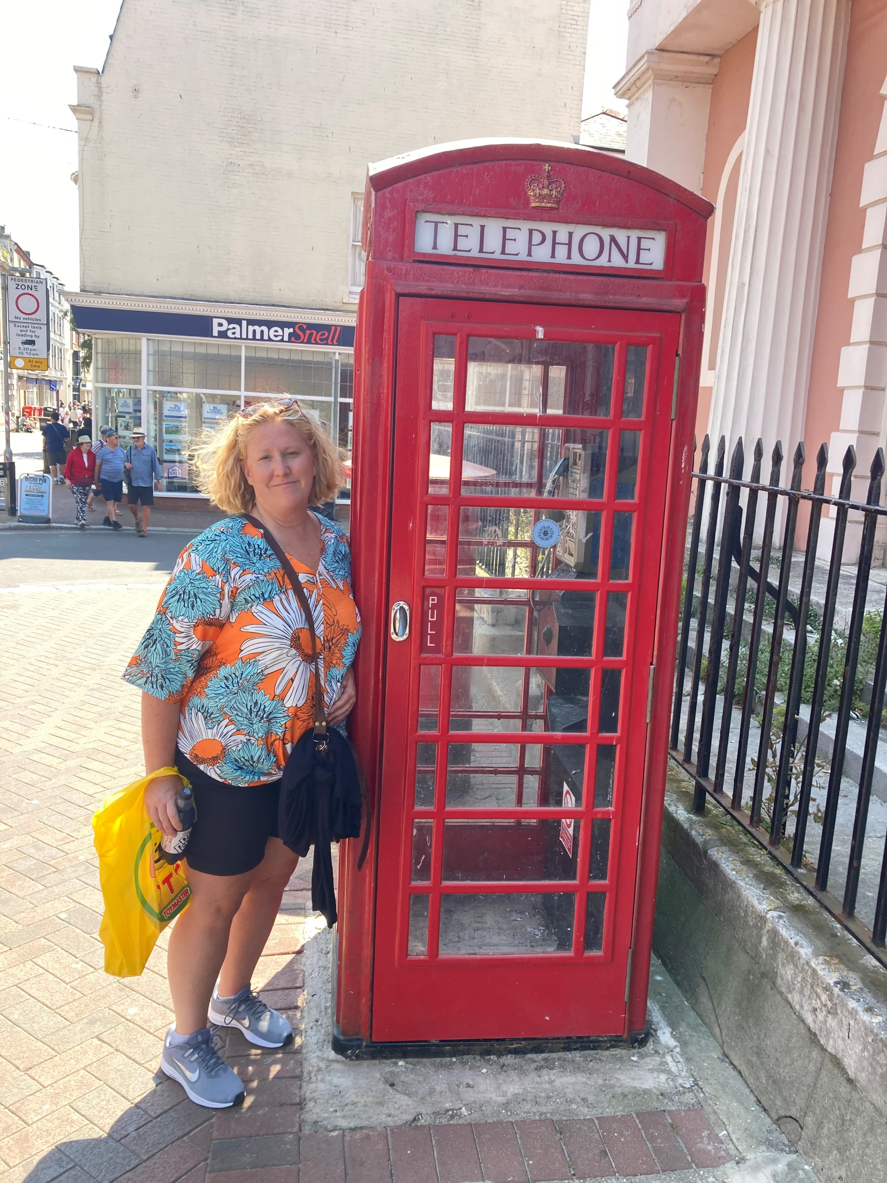 Travel advisor posing with a telephone booth