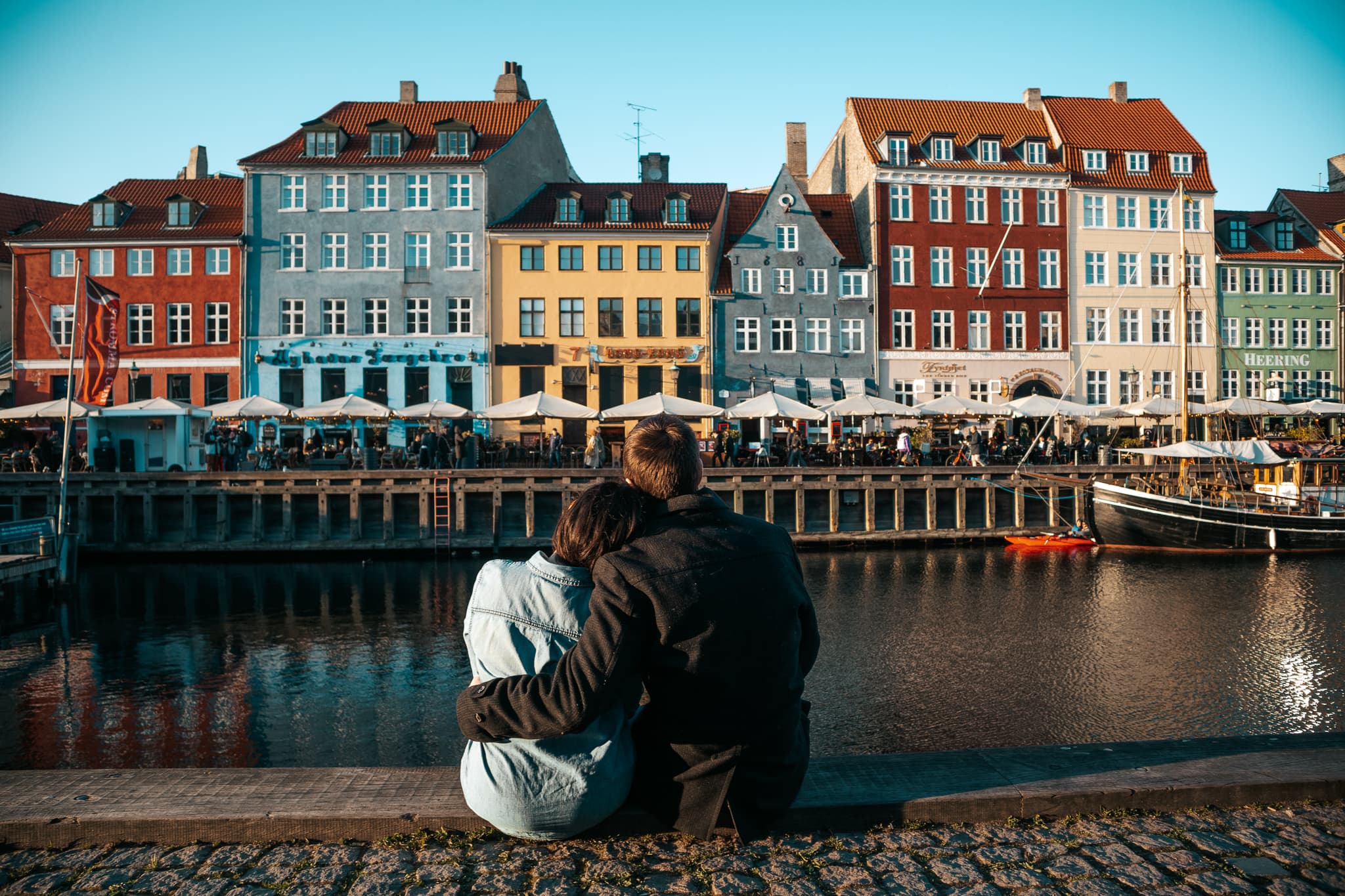 Travel Advisor Diana Morales sitting with another person in front of colorful buildings.