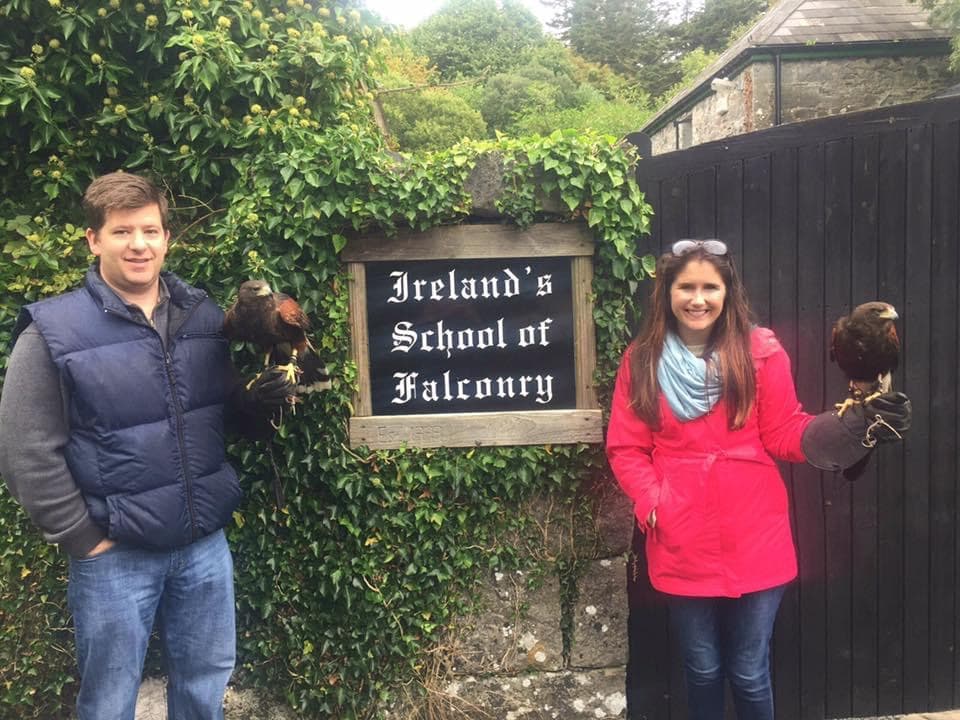 A couple standing at the gate of Ireland's School of Falconry