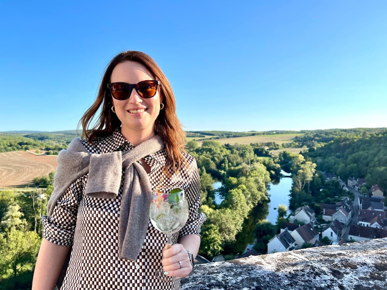 Picture of Elizabeth wearing geometric pattern shirt with a wine glass in hand