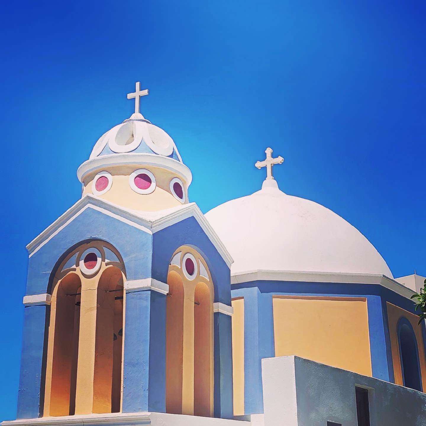 A blue and yellow church with a white dome