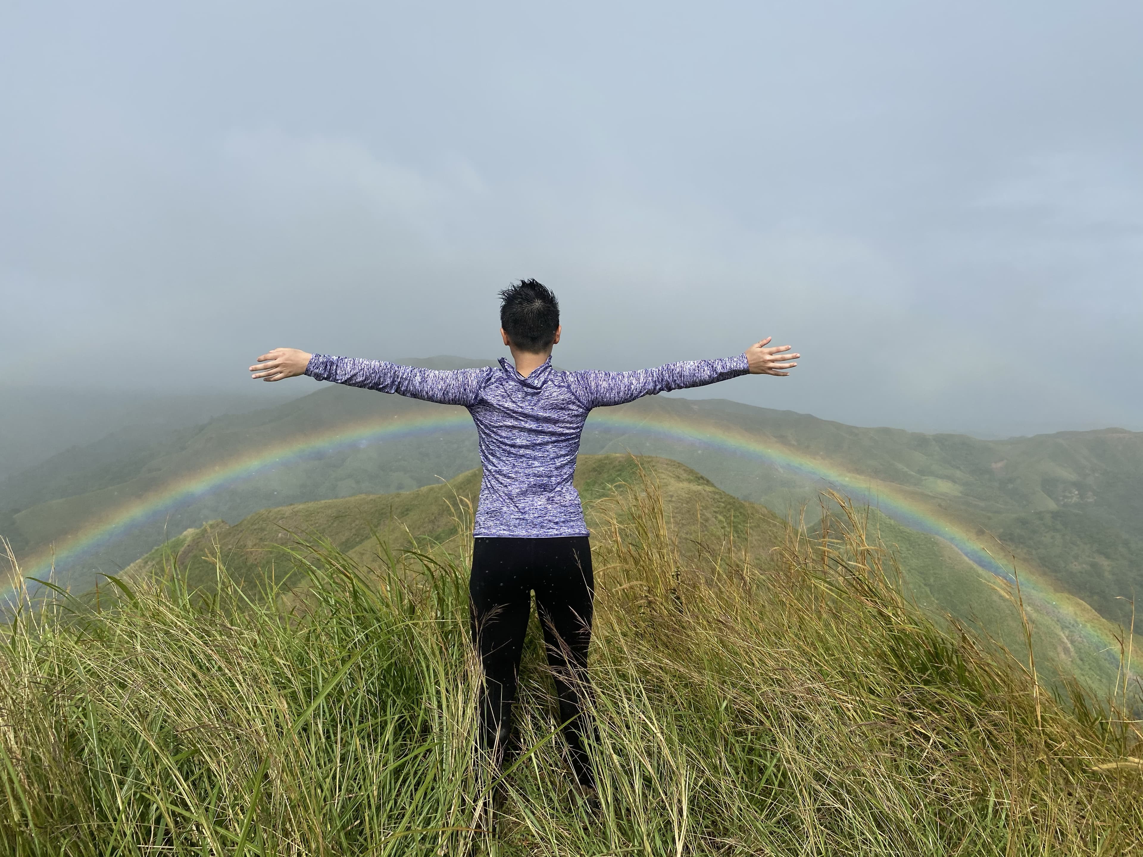Advisor standing with their back to the camera in front of a rainbow