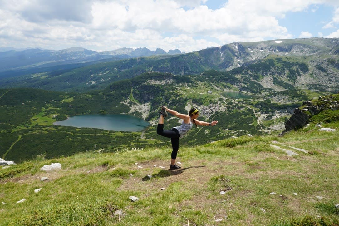 Aashima doing mountain yoga surrounded by beautiful view of greenery and a lake