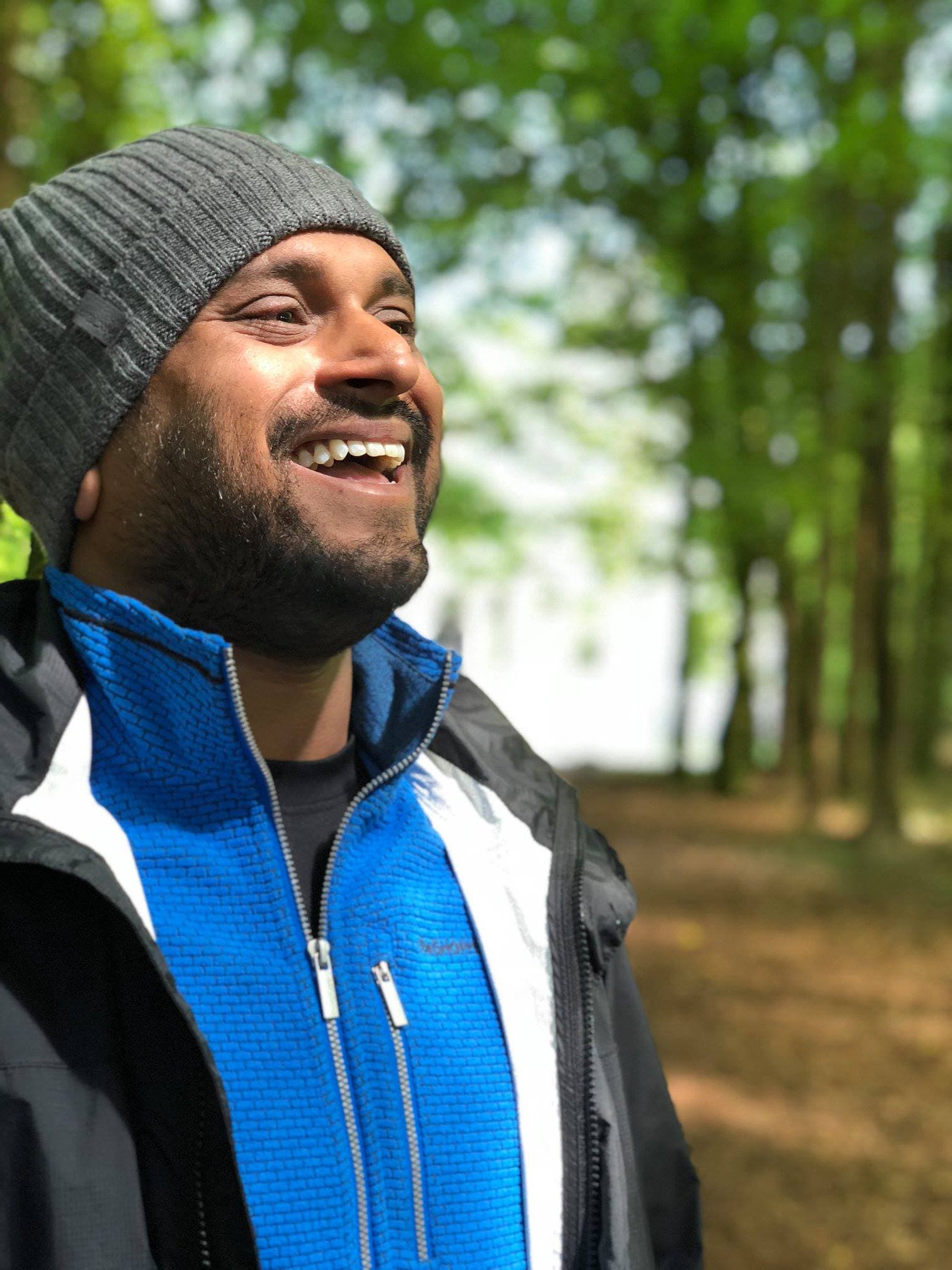 Travel advisor Bijoy smiling in an outdoor natural area with tall trees in the background