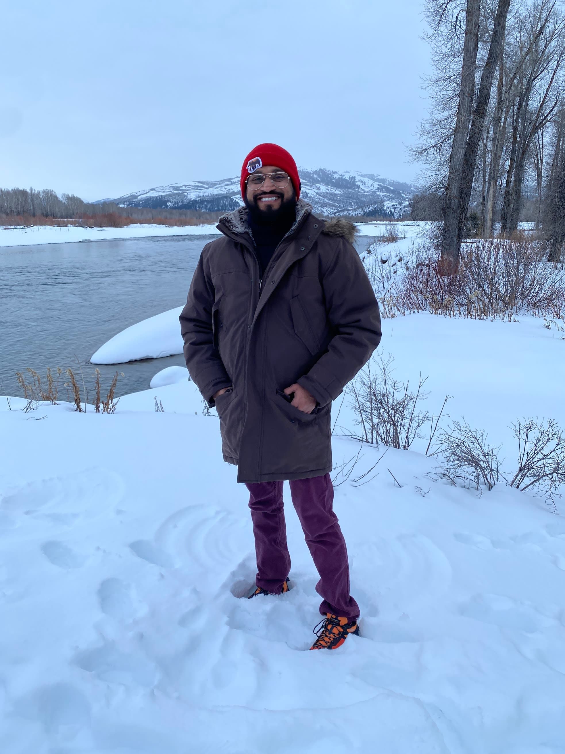 Travel advisor Bijoy Shah standing in a snowy landscape by a lake