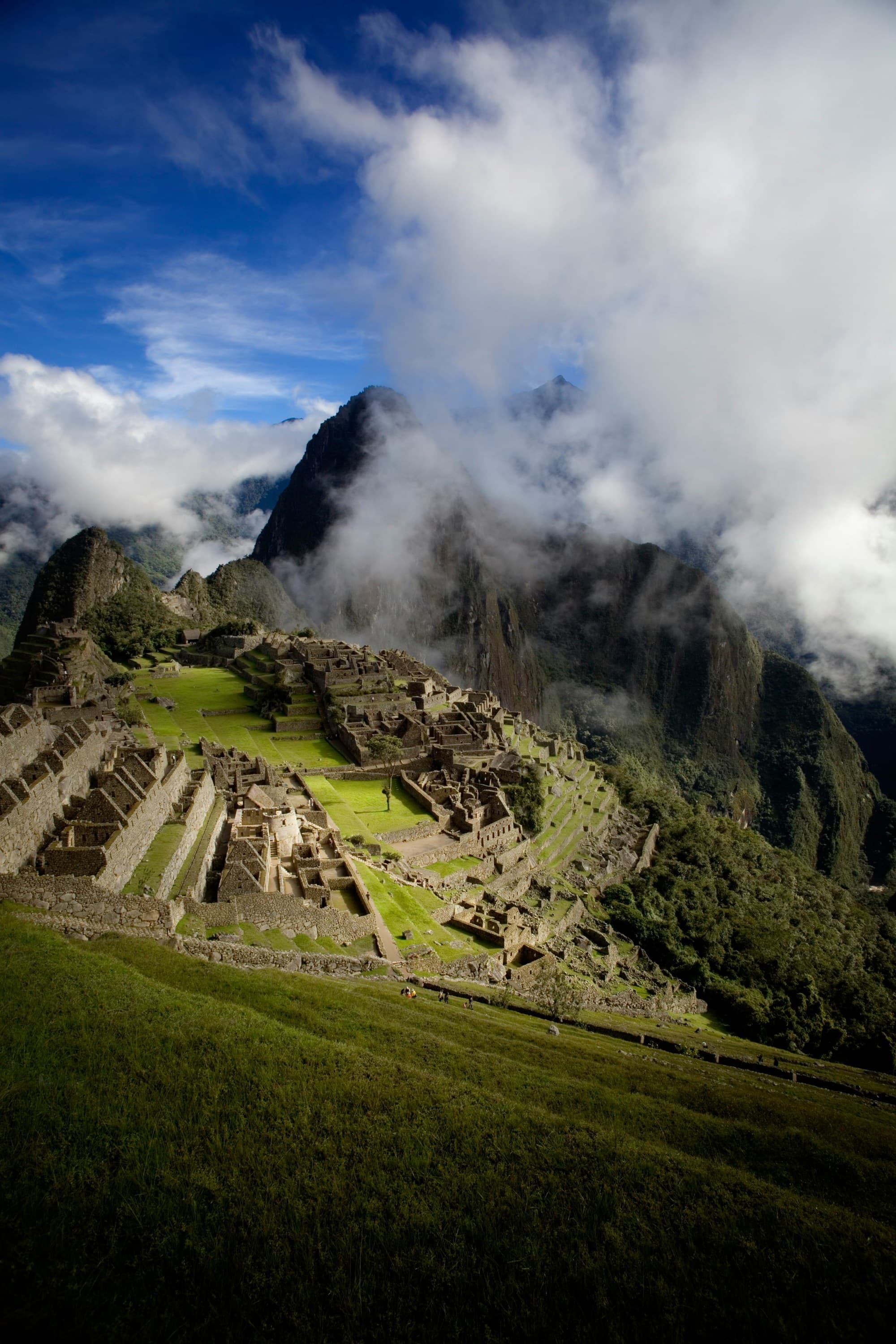 Majestic mountains and clouds surround the ancient Incan city of Machu Picchu.