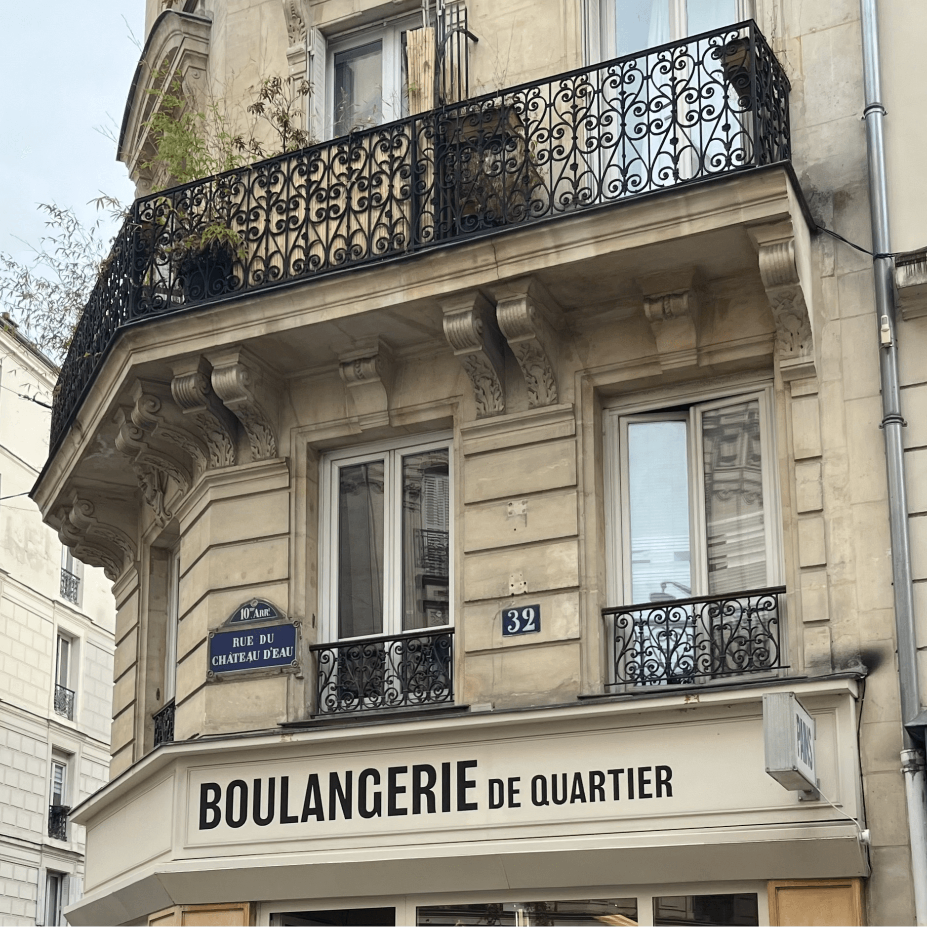 The upper floors of a building have a sign that reads “BOULANGERIE DE QUARTIER” and street signs indicating “RUE DU CHERCHE-MIDI” and “39.”